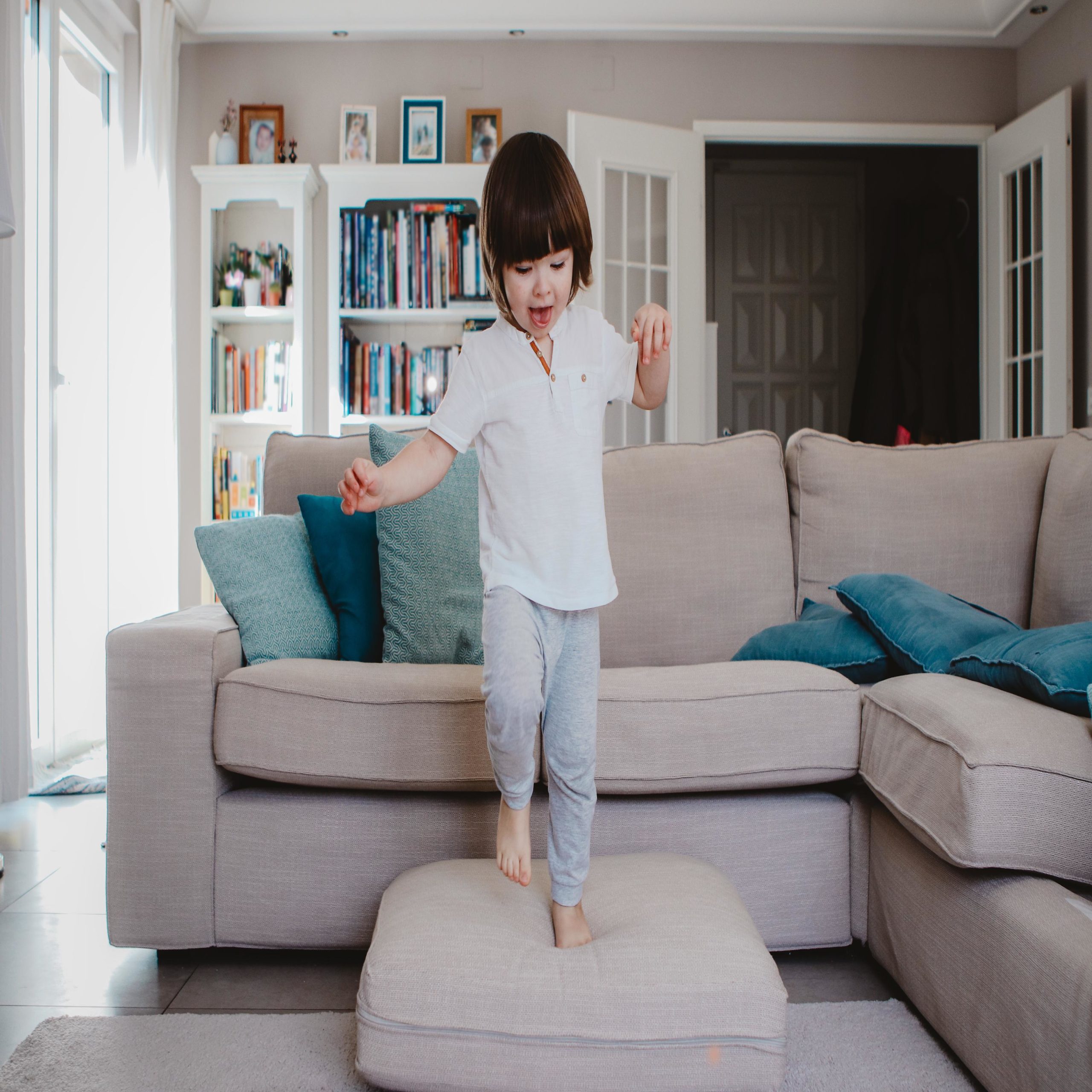 toddler standing on an ottoman