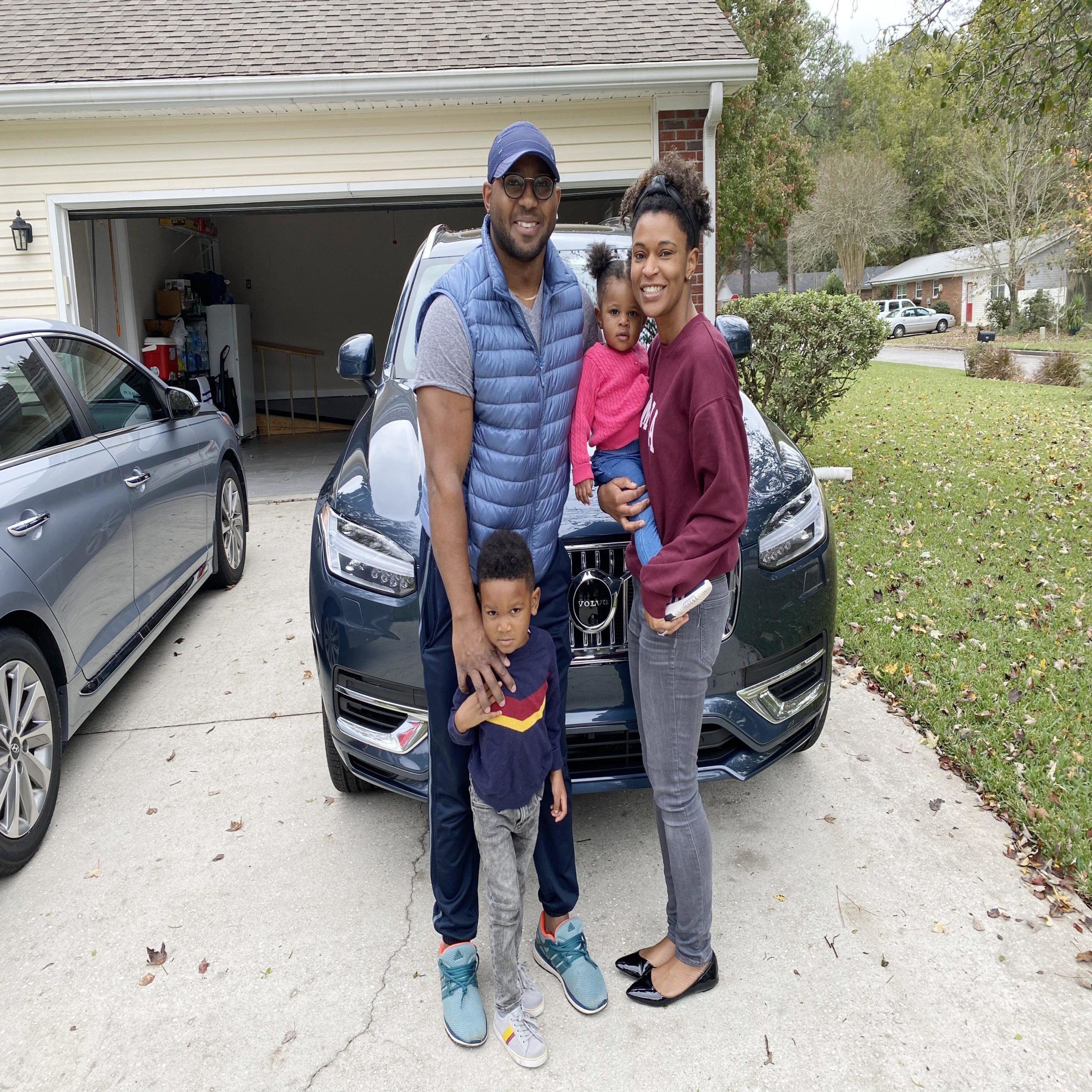 family standing outside of their Volvo