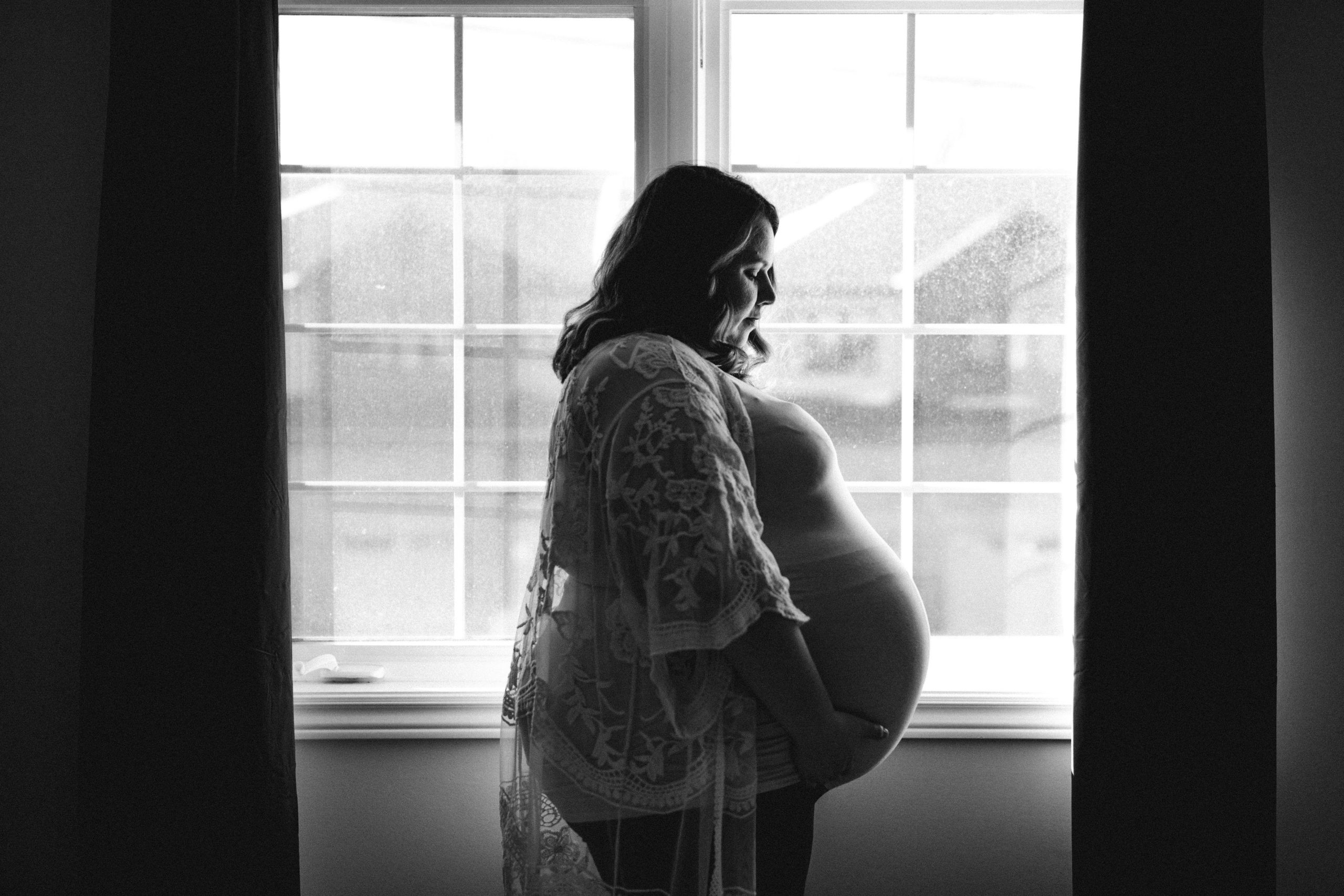 pregnant mom silhouette in front of a window