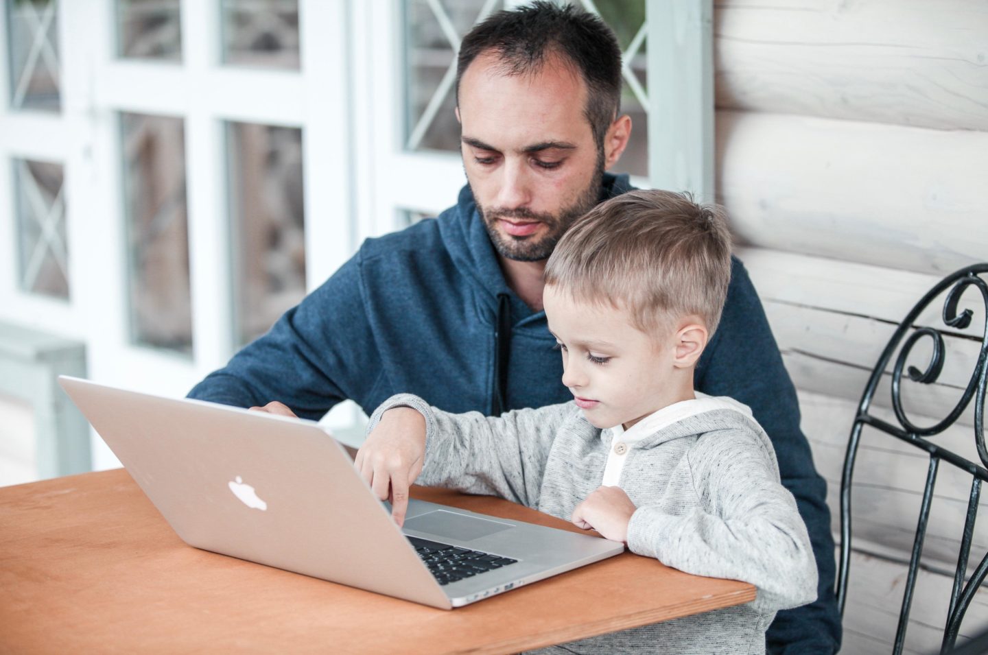 dad working on a laptop with son in his lap