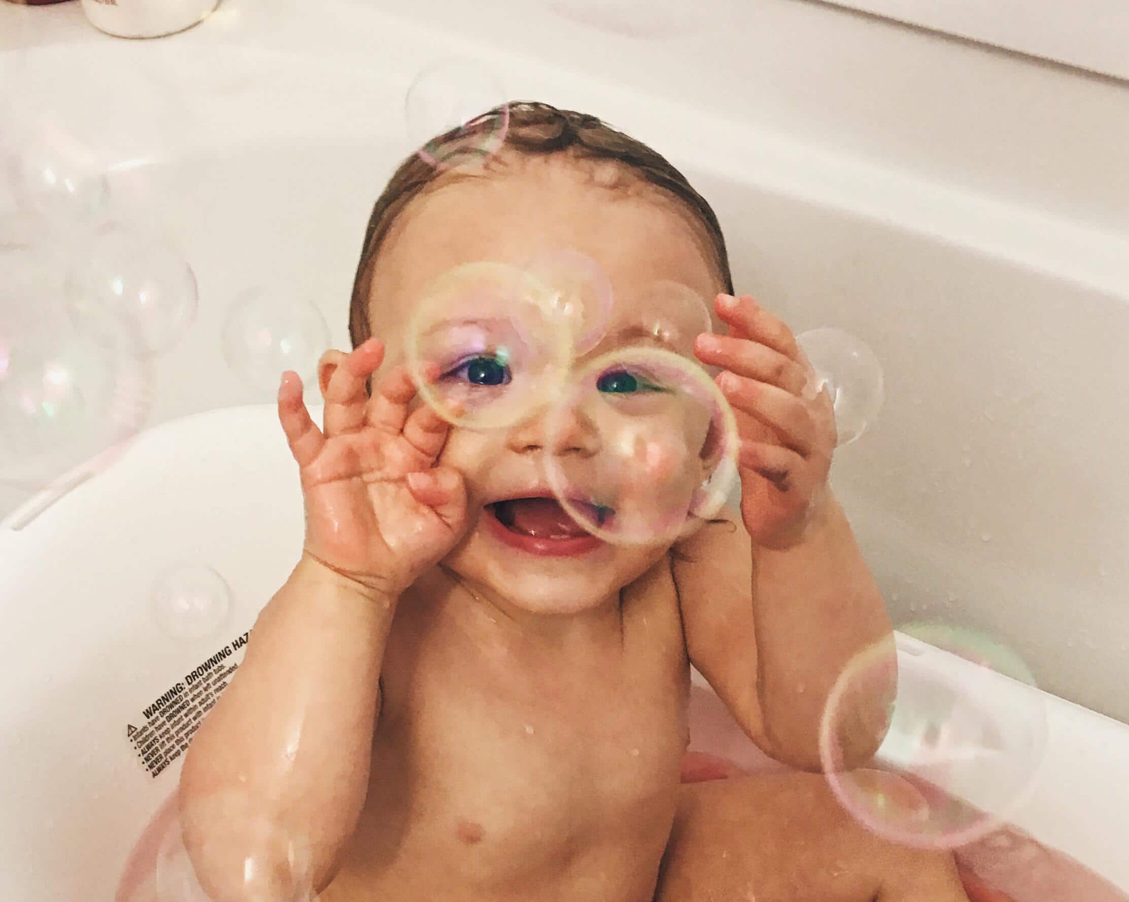 child in the bath tub playing with bubbles- pisces names