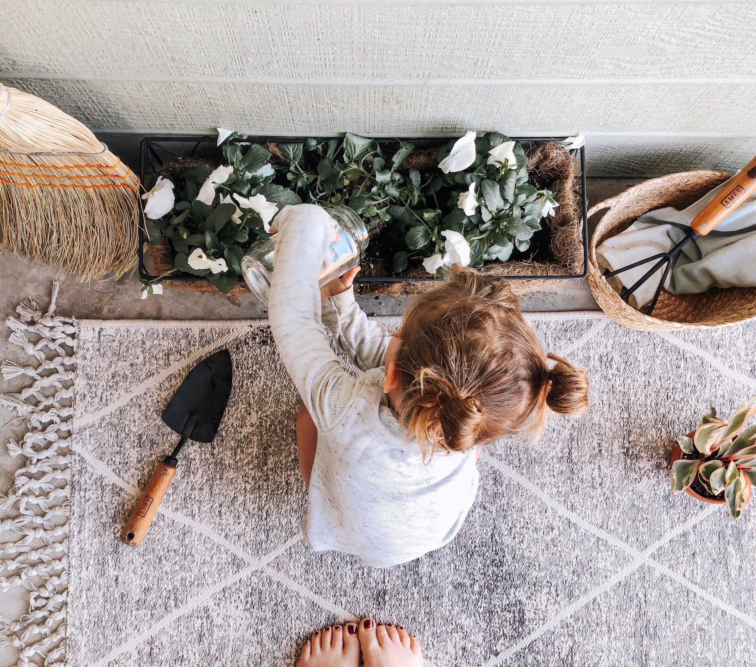 child watering a plant- montessori chores by age