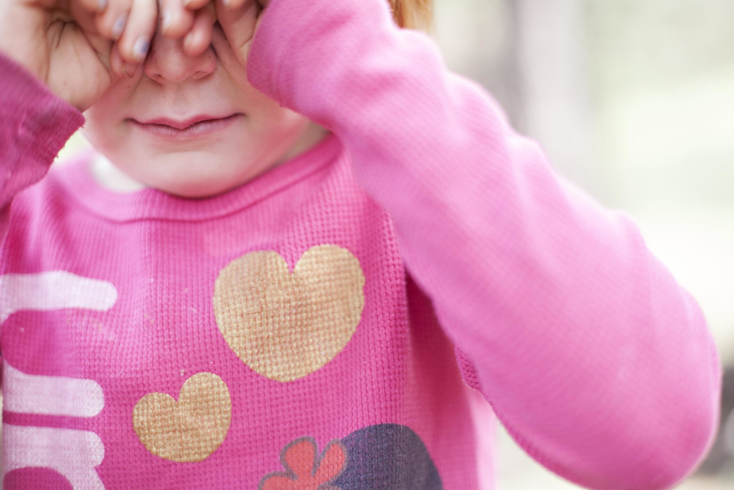 little girl playing peek a boo