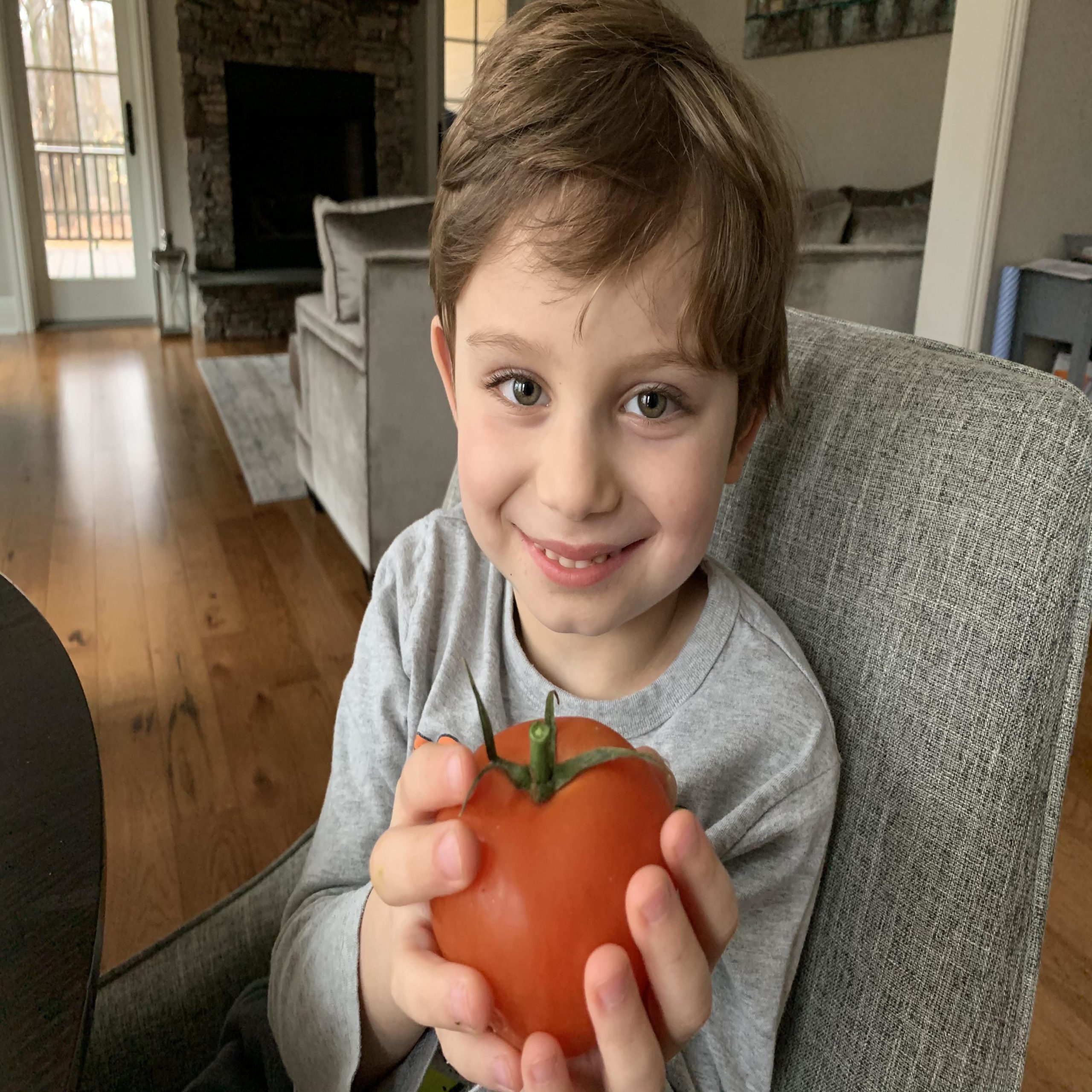 little boy holding a tomato