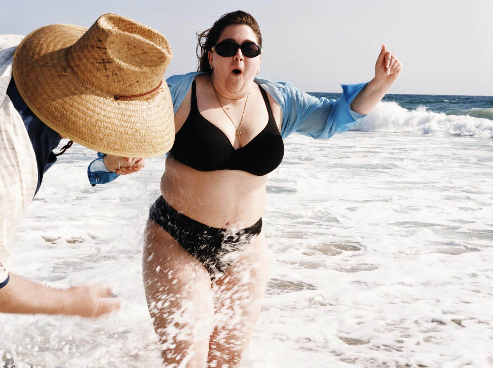 woman splashing in the ocean wearing a bikini