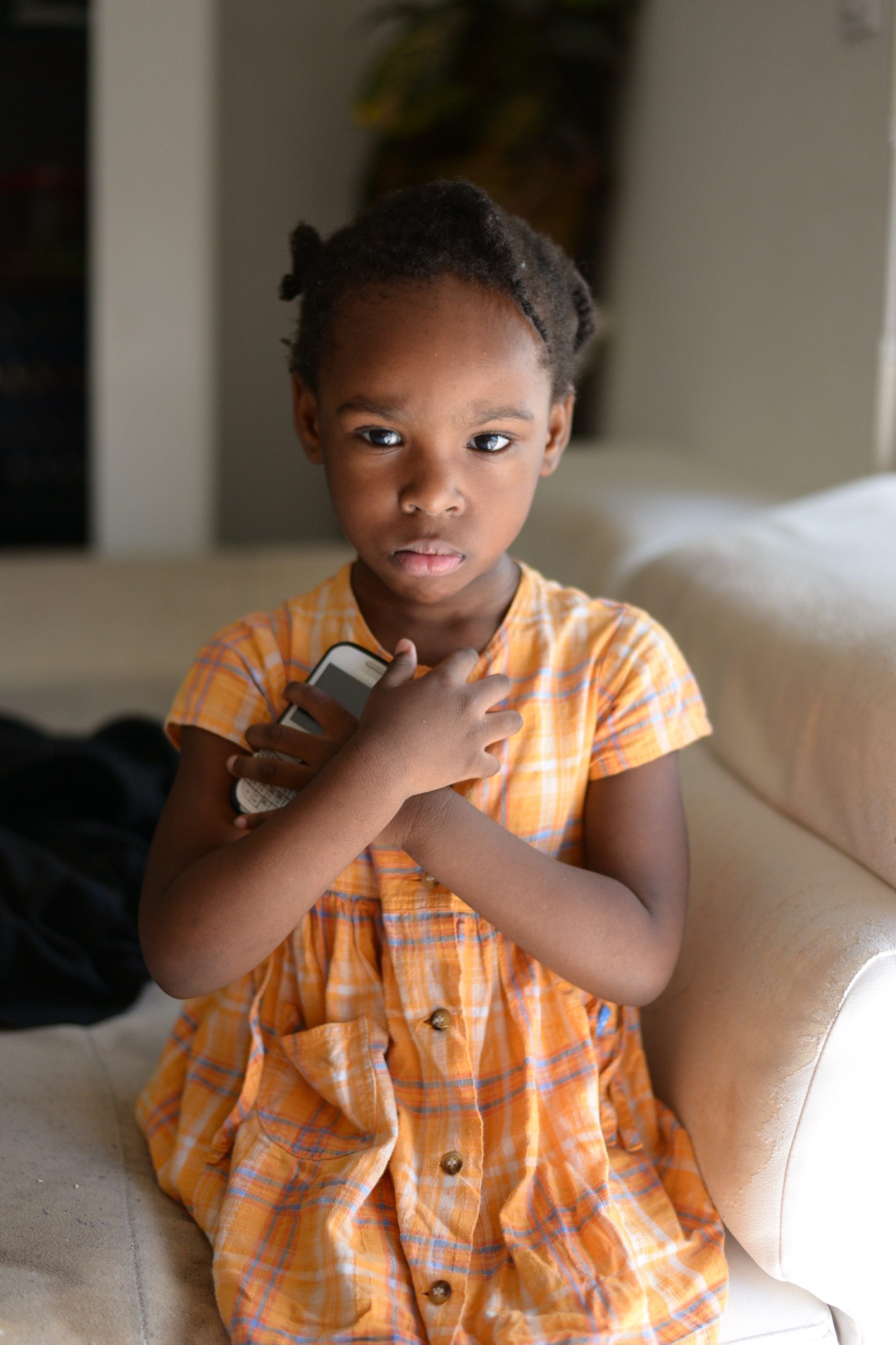 little girl holding a phone to her chest