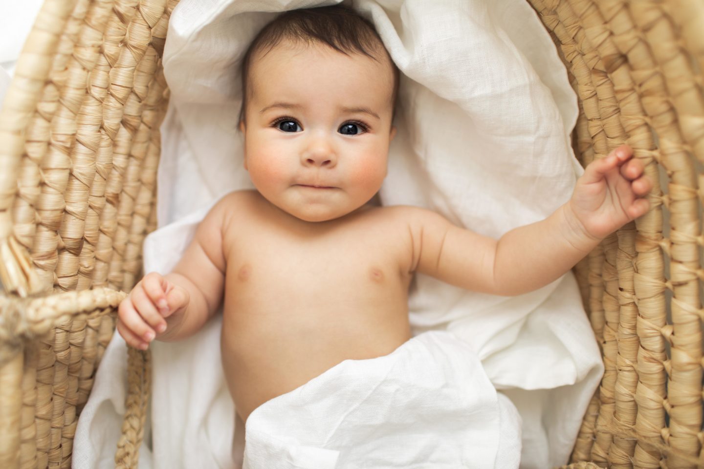 baby in a bassinet with a blanket