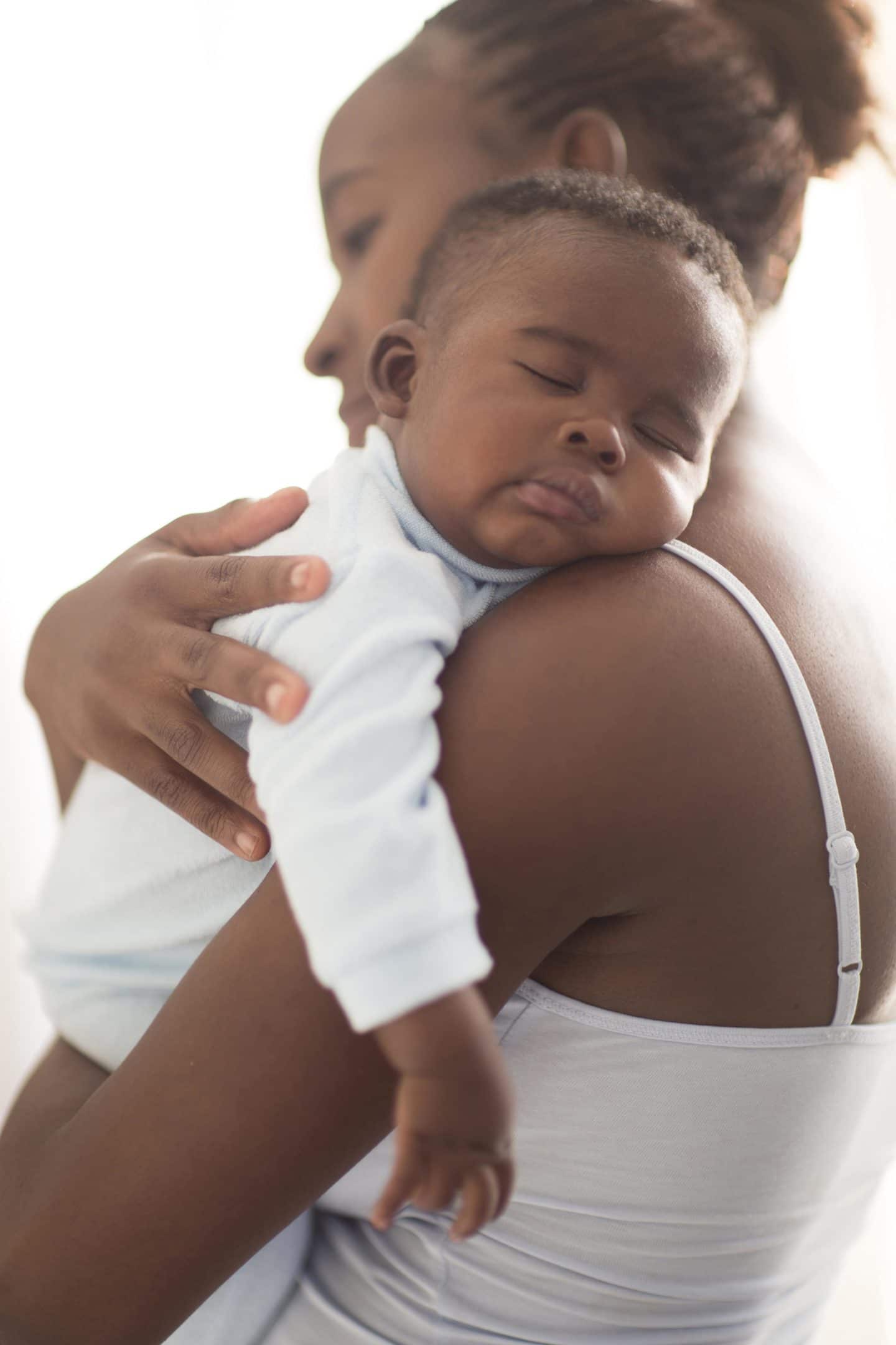racial disparity: mother holds sleeping infant