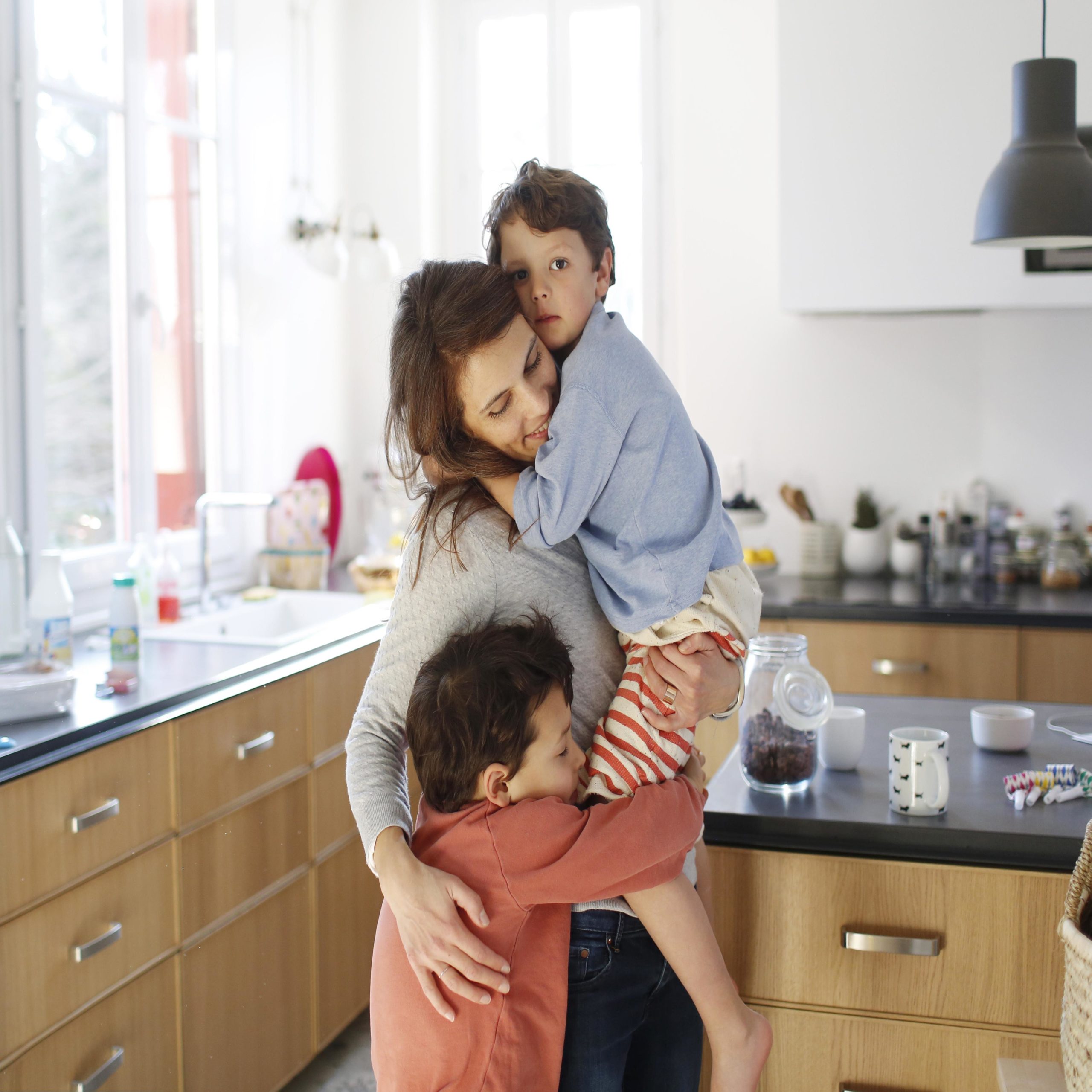 mom hugging two kids