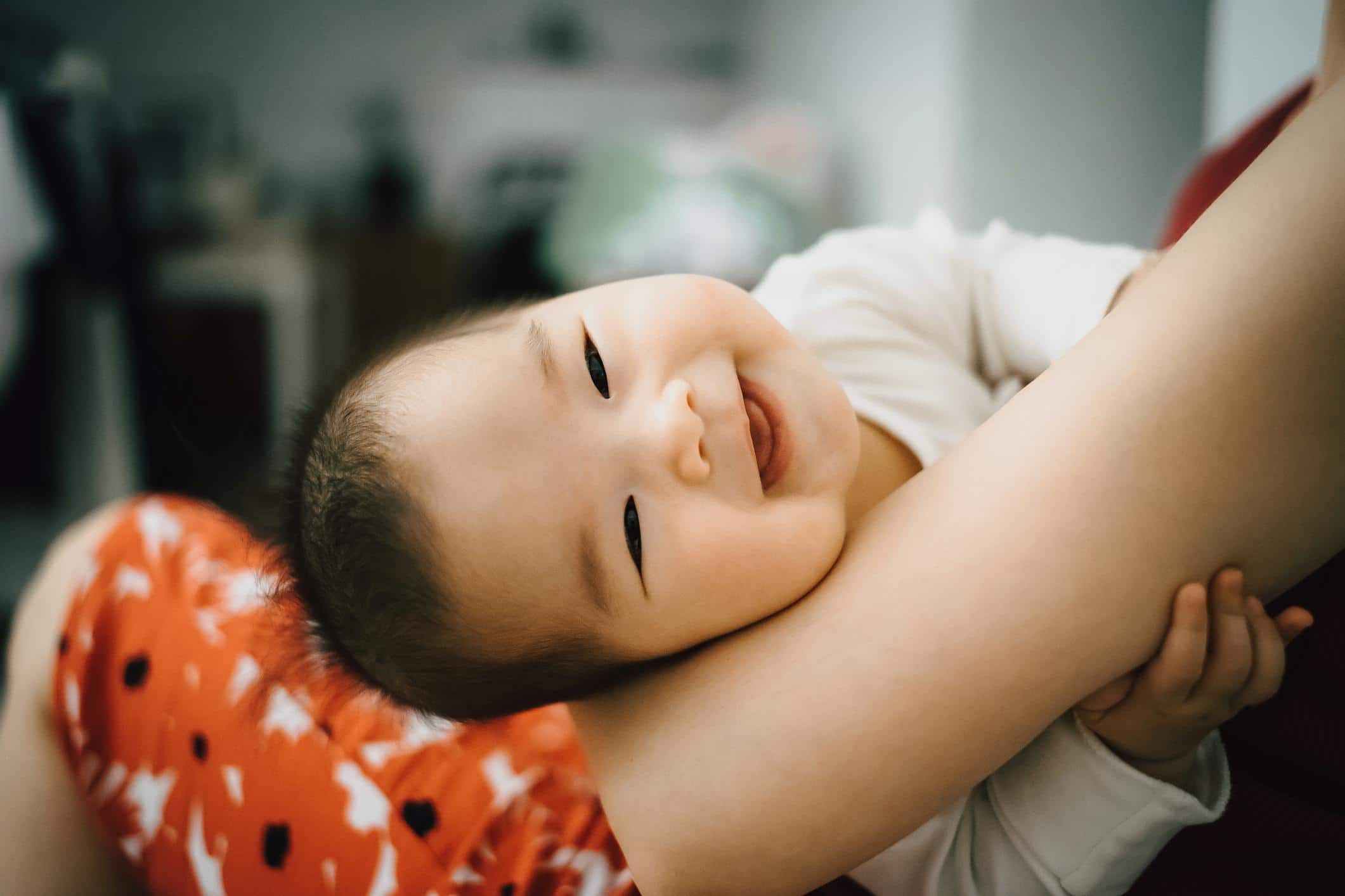 cute baby laying on moms arms