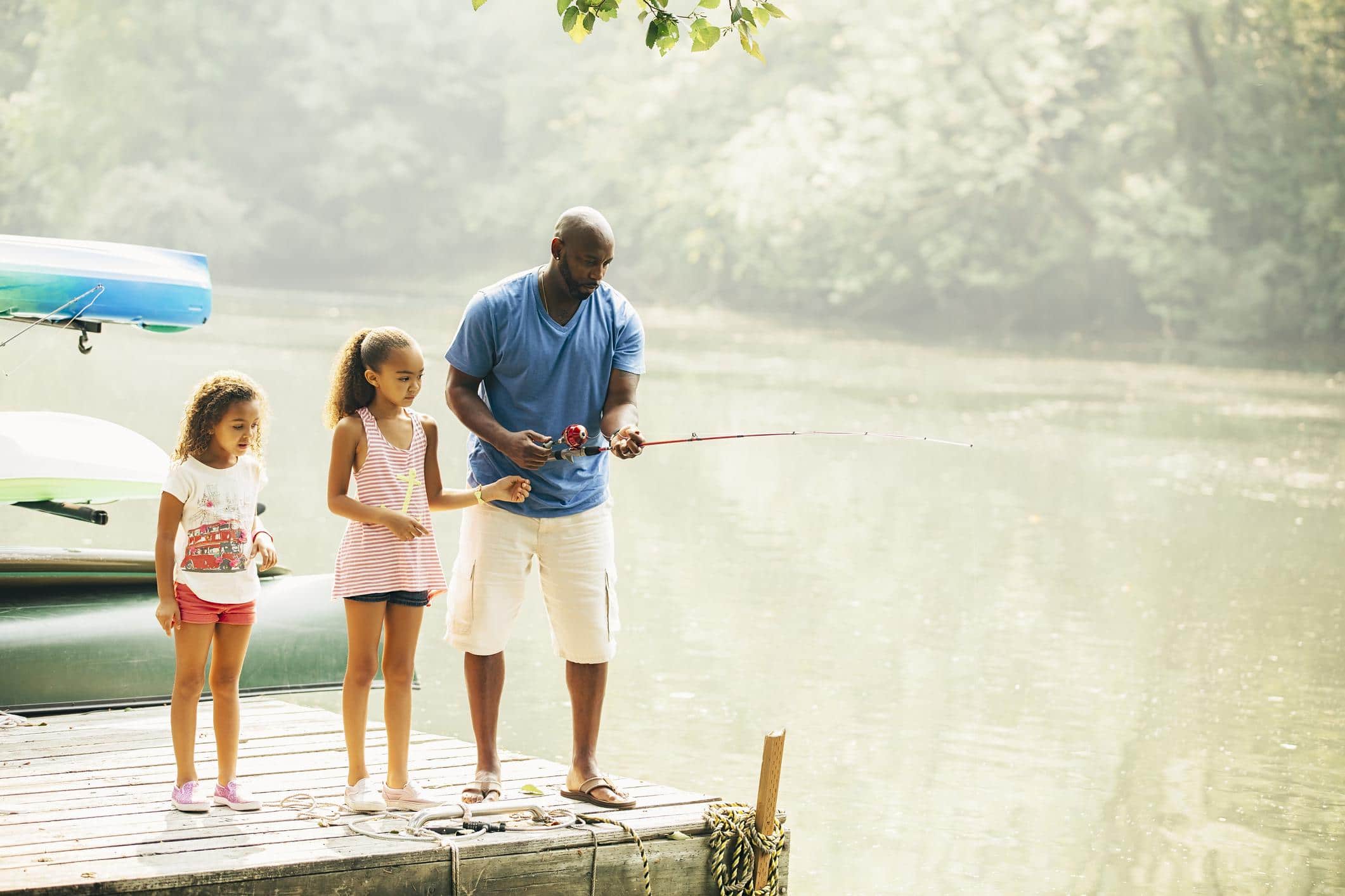 dad fishing with two daughters