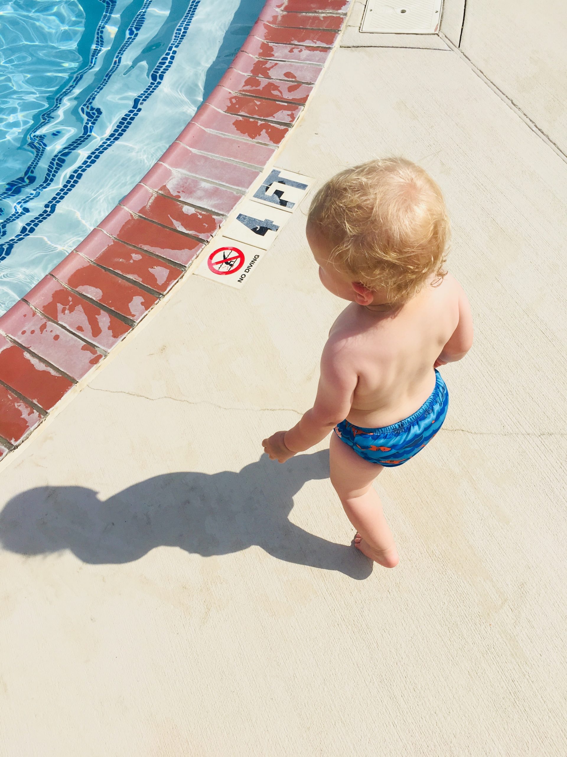 child walking on the edge of a pool
