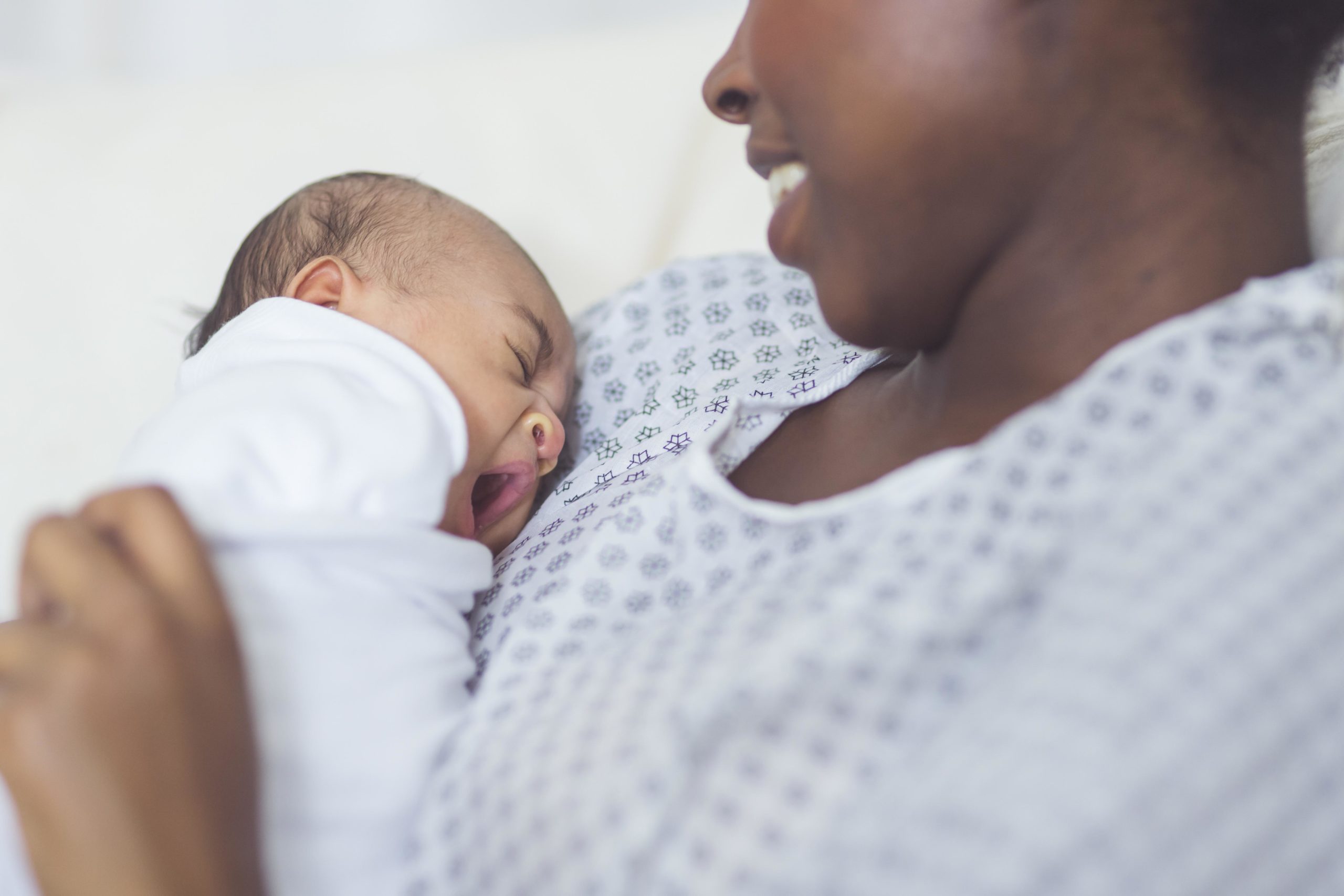 mom holding newborn baby in hospital