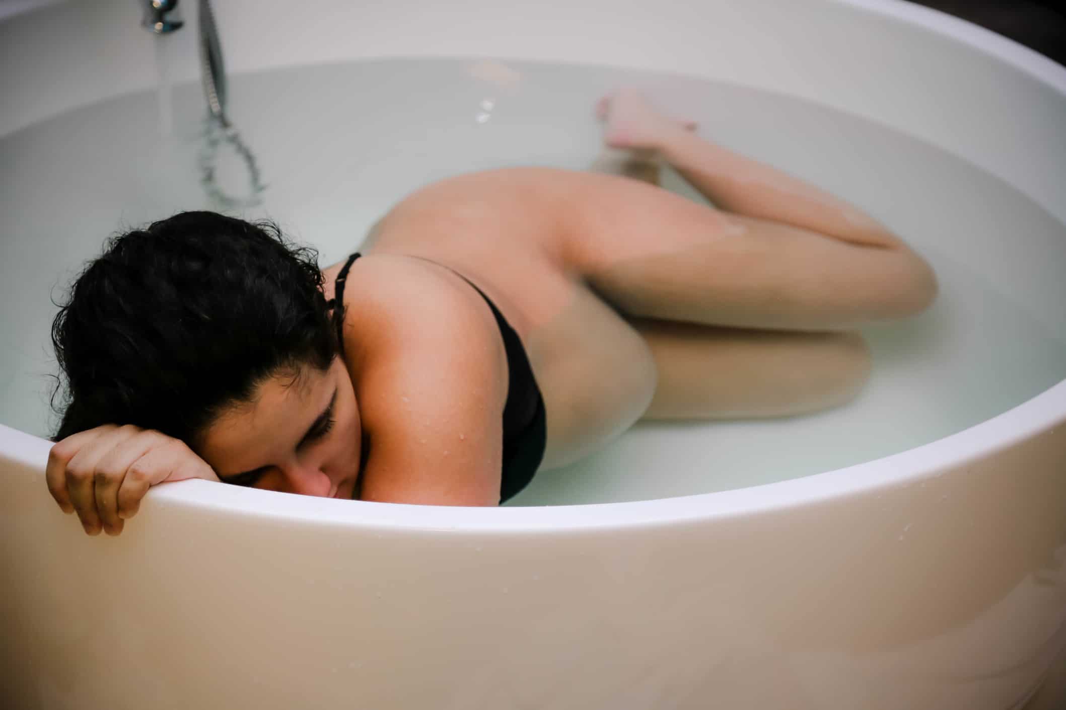 woman in tub during labor - pregnant people are endurance athletes