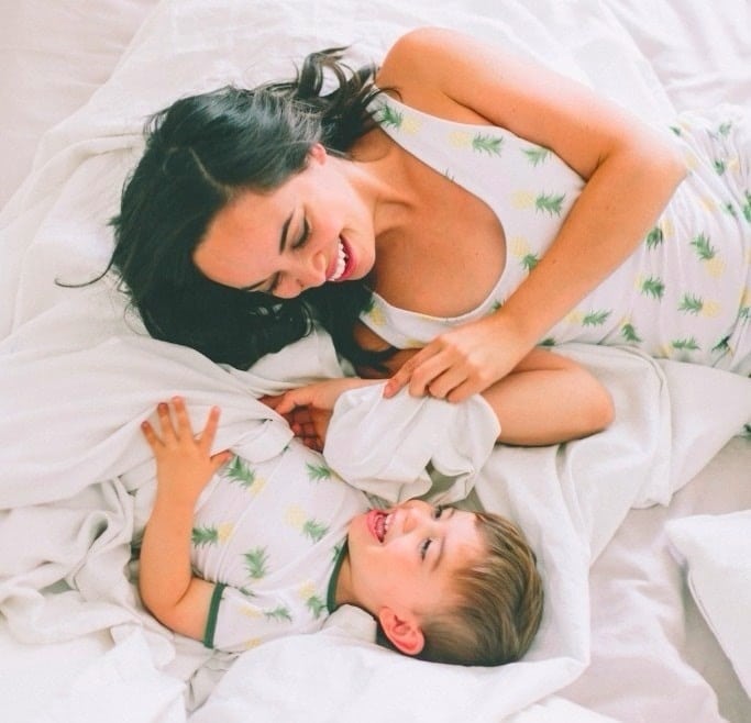 mom and son laughing on a bed