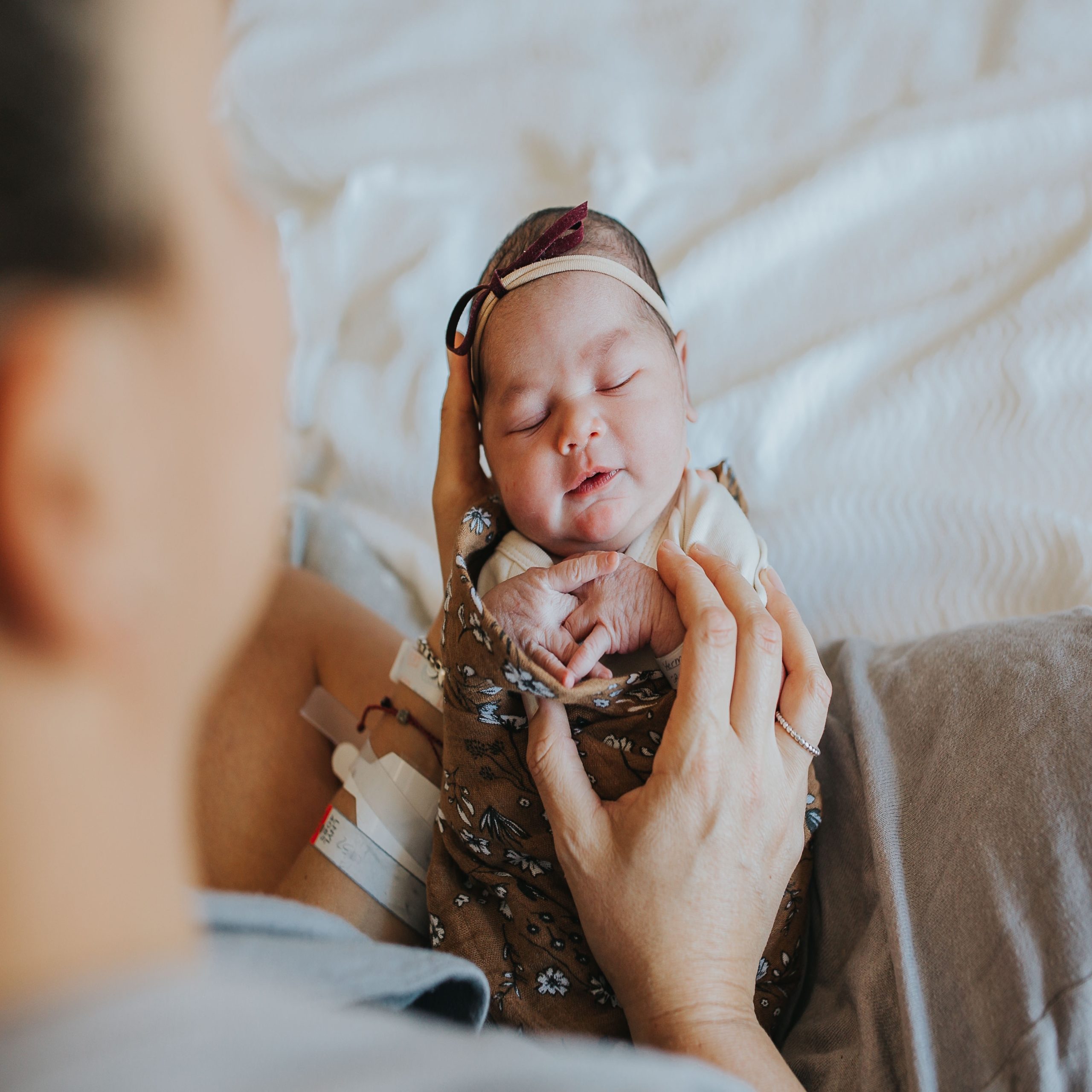 mom looking at newborn baby swaddled up - easy baby