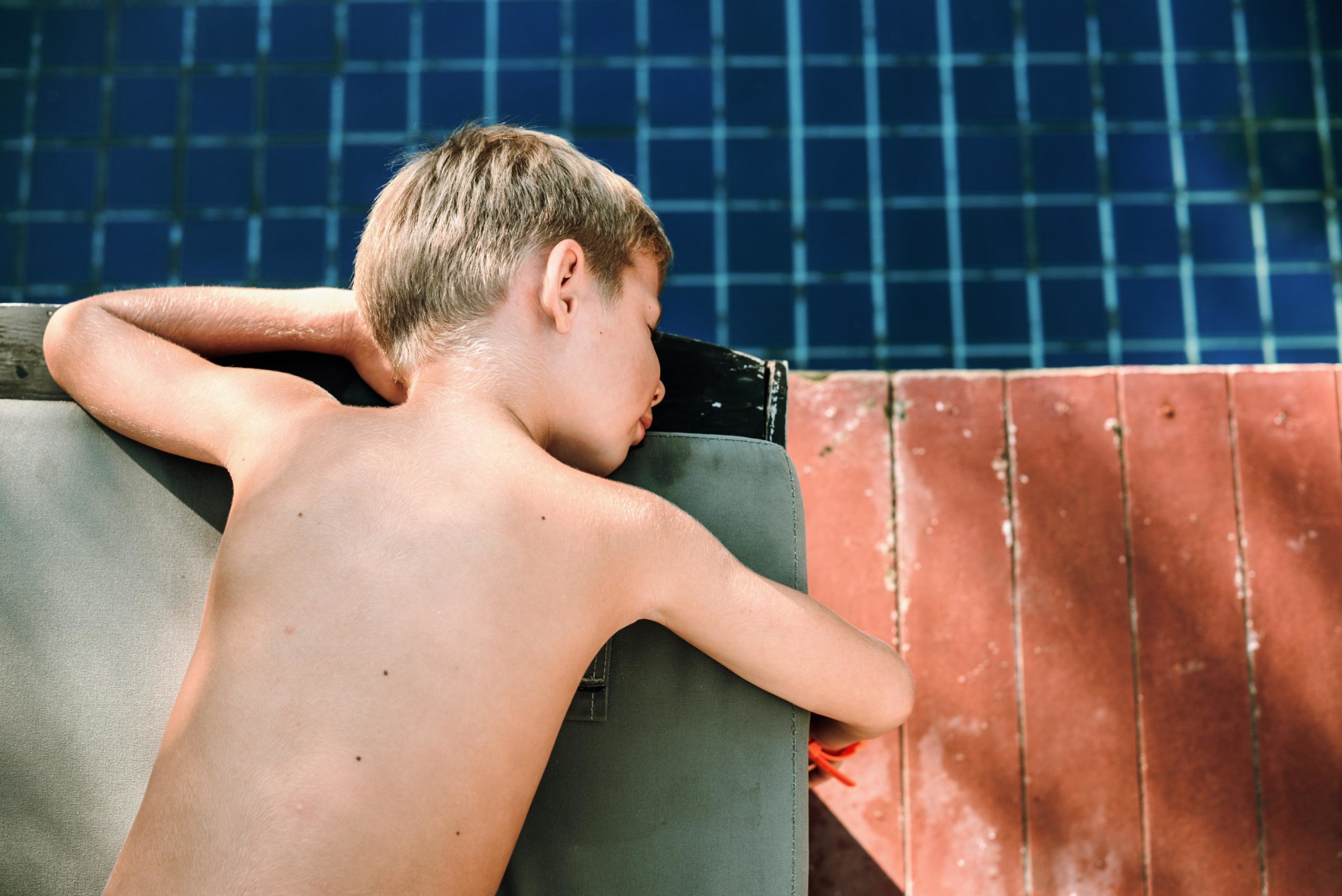 child dipping his hand into a pool