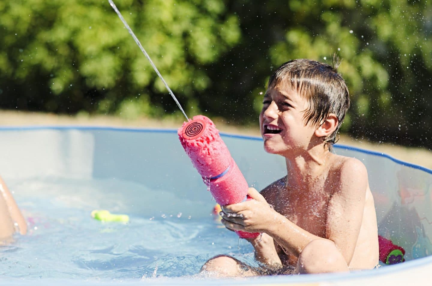 little kid playing with a pool toy