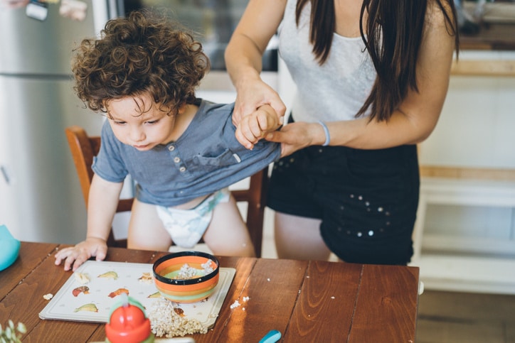 mom handling a child at the table