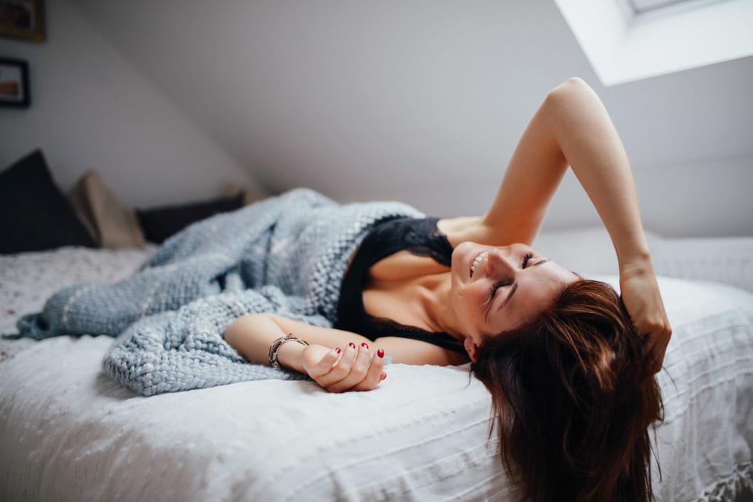 woman laying on a bed - signs of ovulation guide