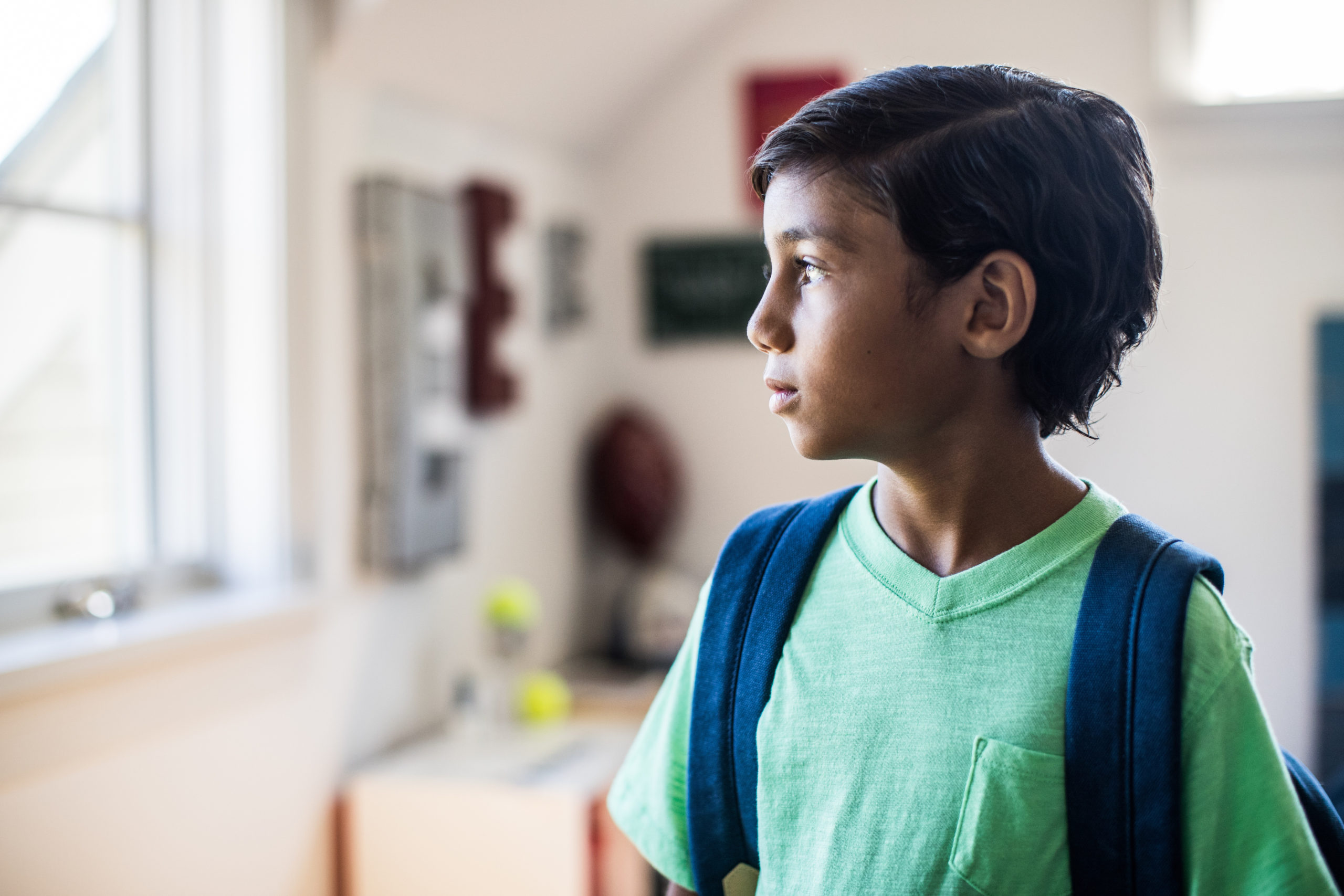 little boy looking out window at school