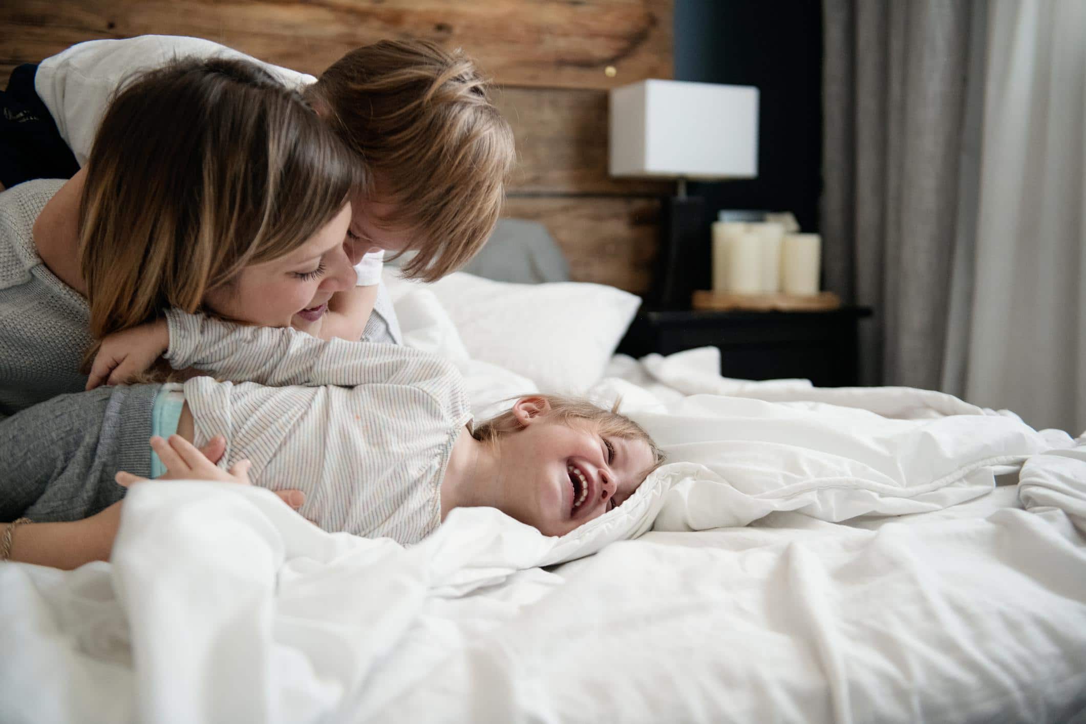 mom hugging toddler in bed