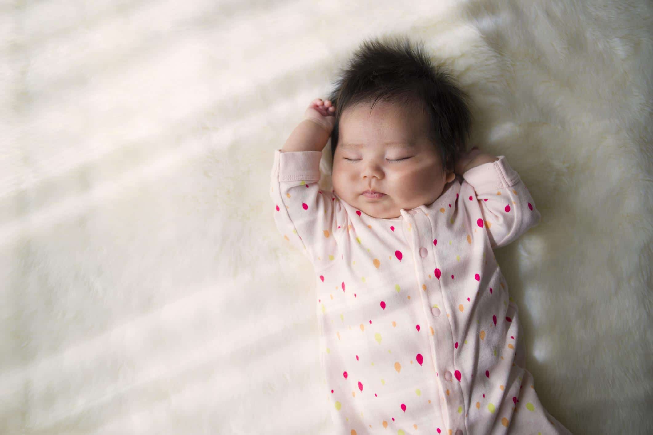 four-week-old baby sleeping in the sun from a window