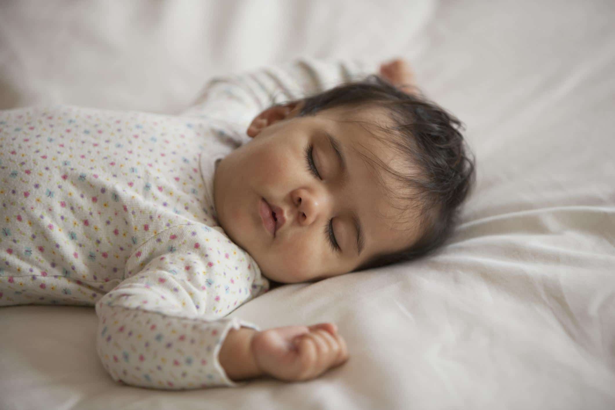 10-month-old baby sleeping on a bed