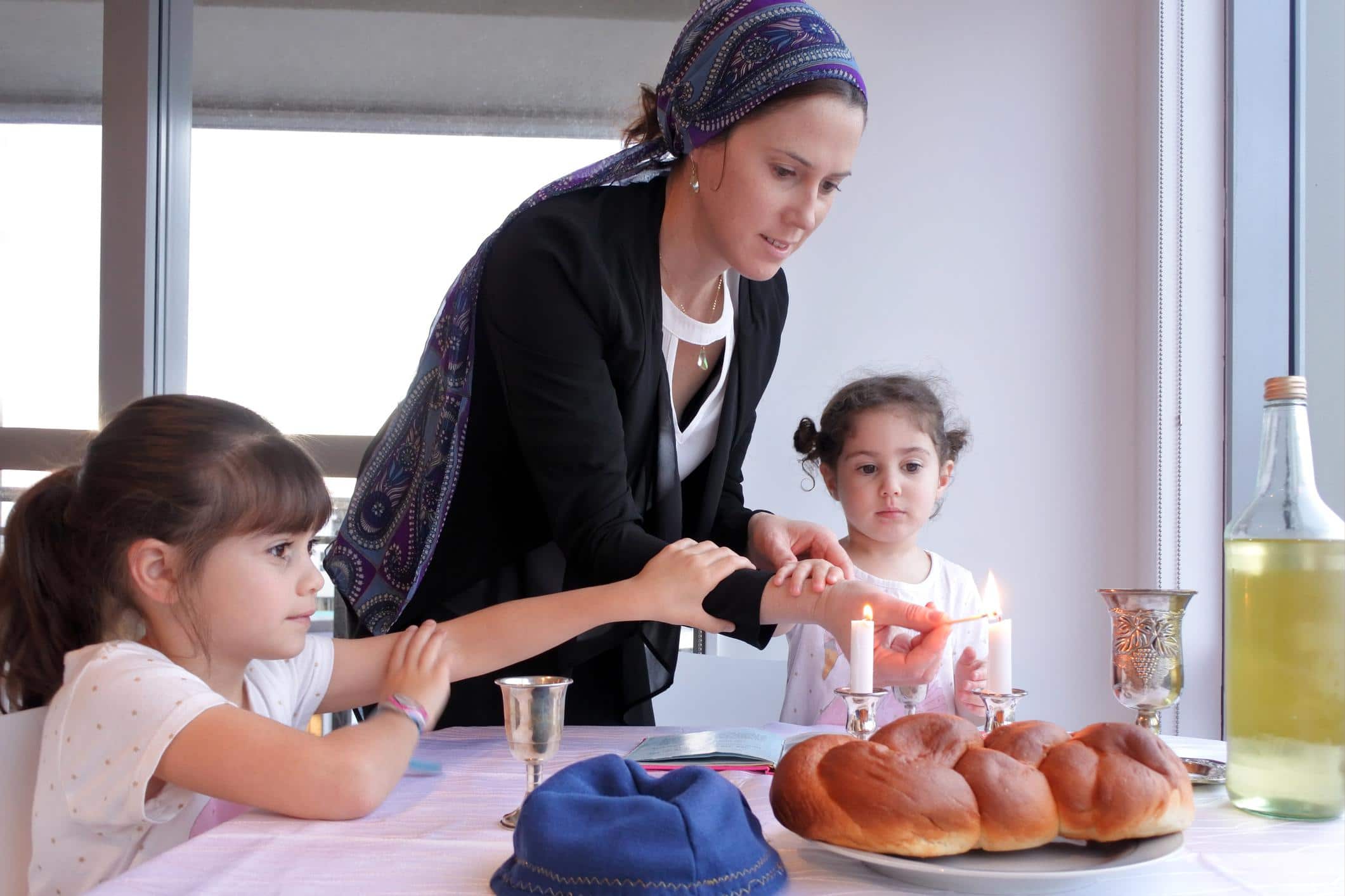 mom feeding her kids the sabbath meal - how to raise proud Jewish kids