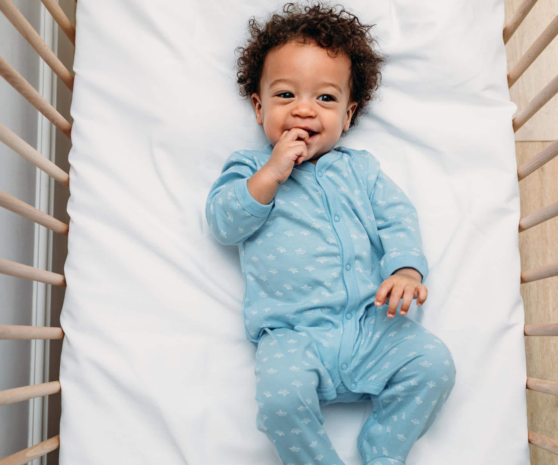 8-month-old baby laying in their crib