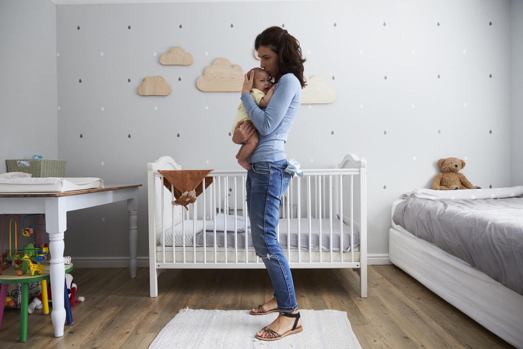 mom holding baby outside of her crib- sahm