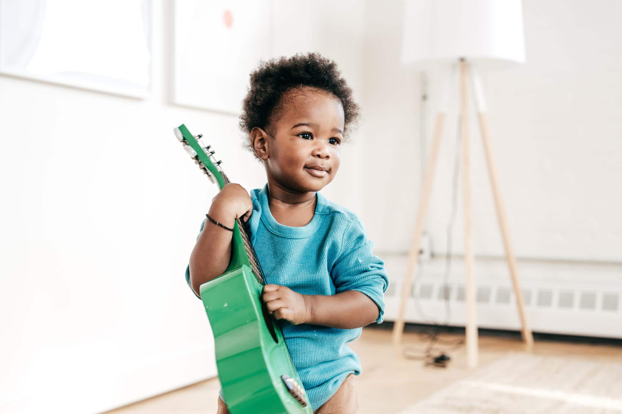 little boy playing with a toy guitar