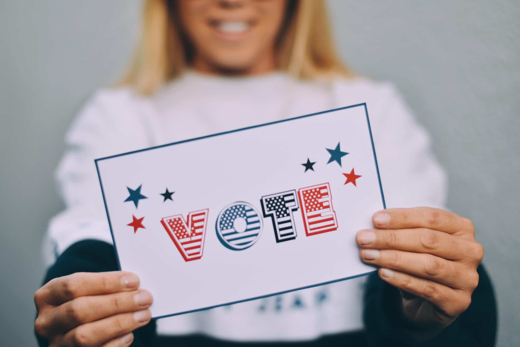 woman holding vote sign- guide to voting