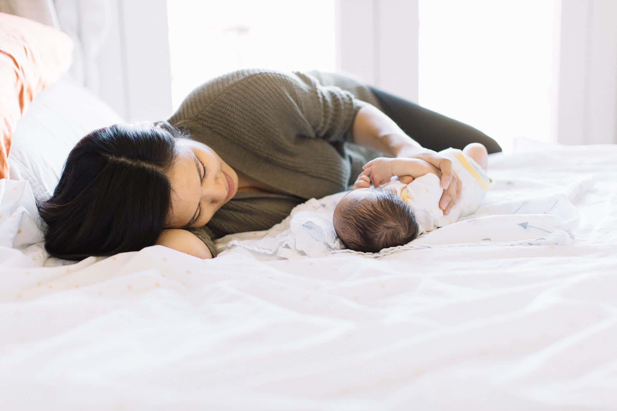 mom laying in bed with baby