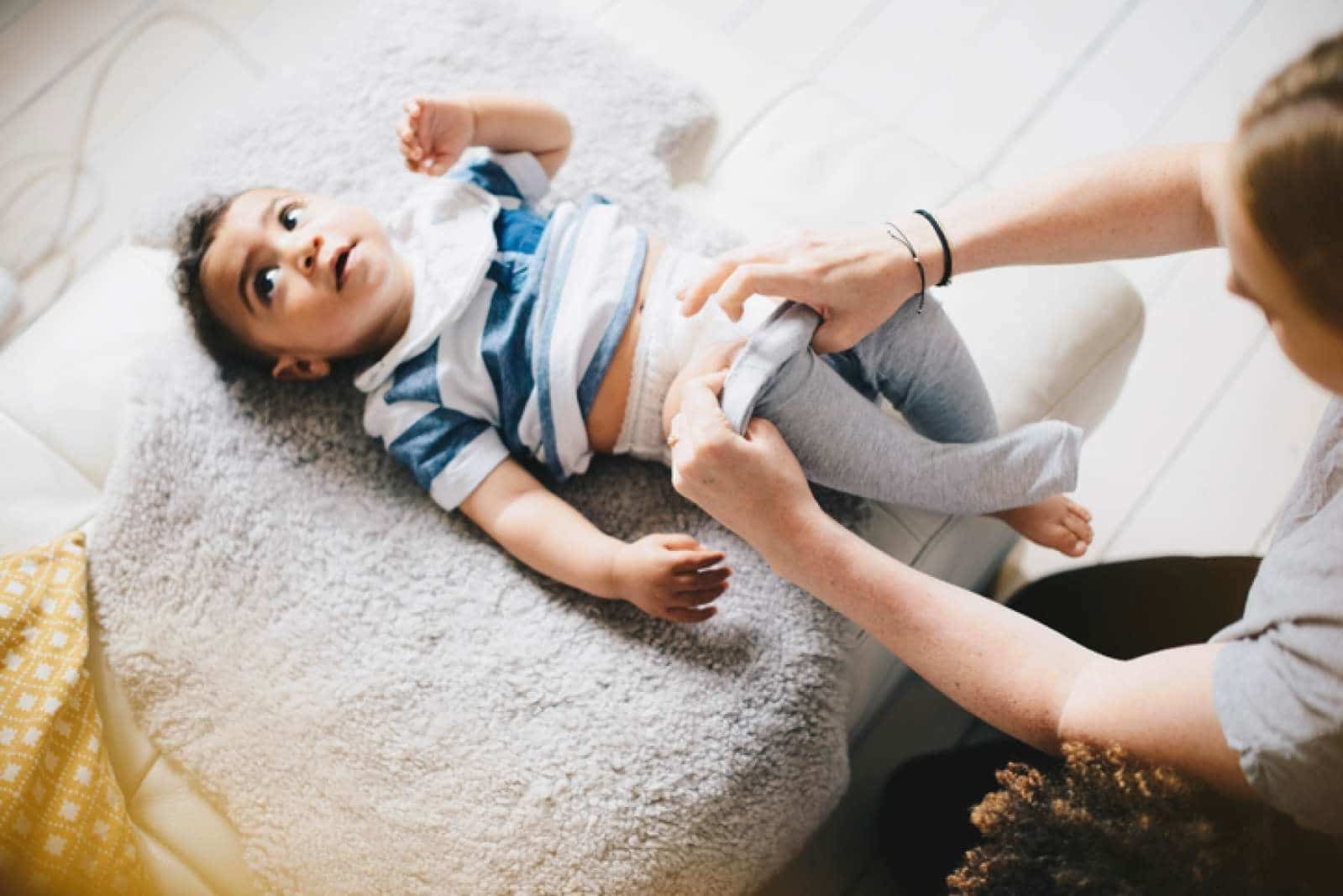 mom dressing a toddler