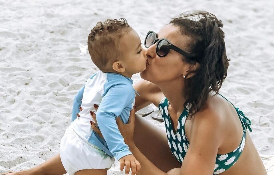 mom kissing baby on a beach