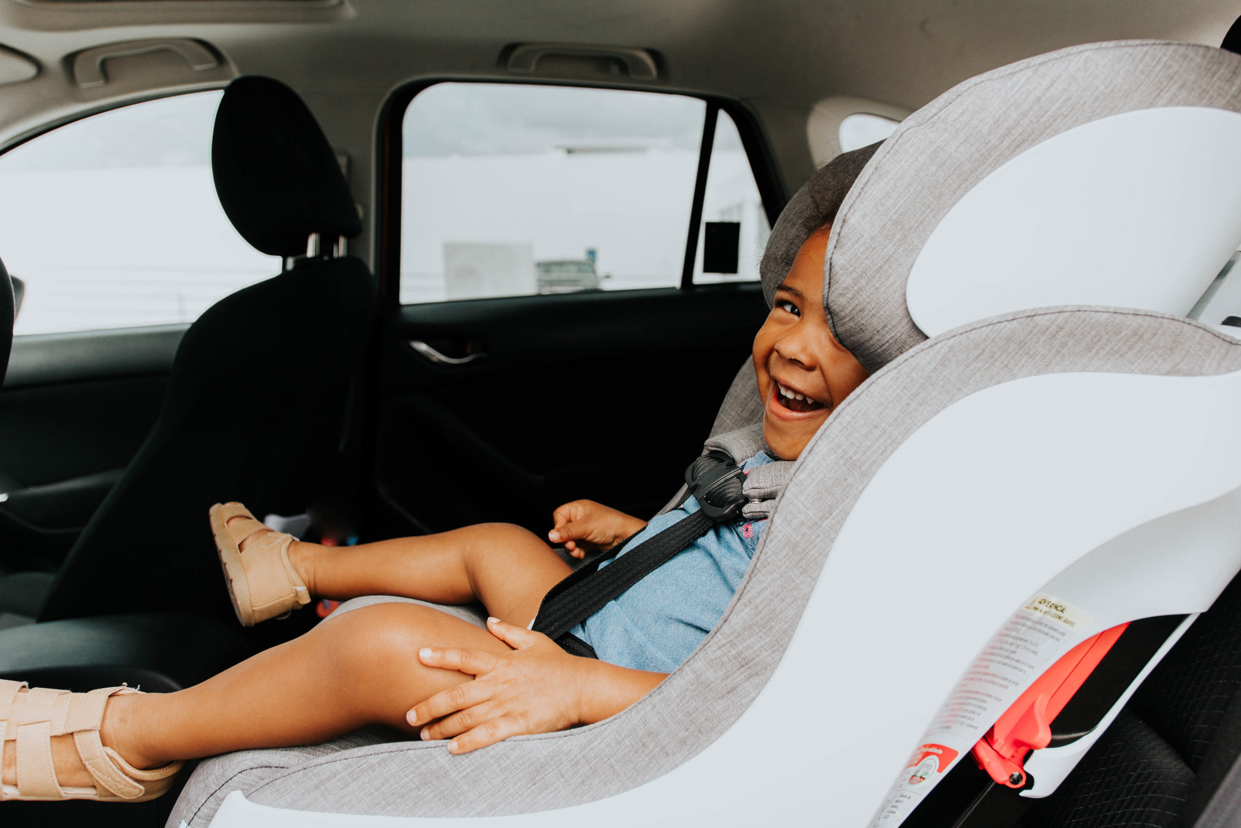 toddler laughing in a car seat