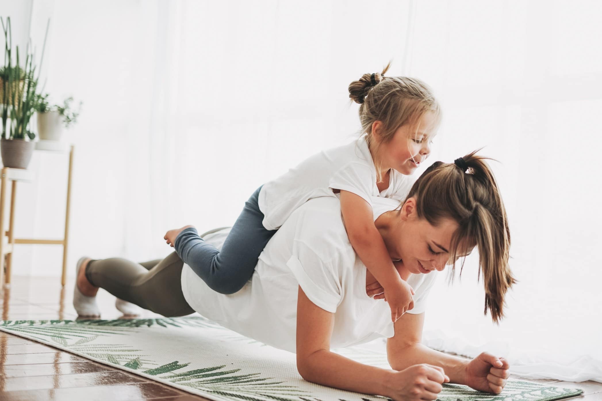 mom doing a plank with daughter on her back