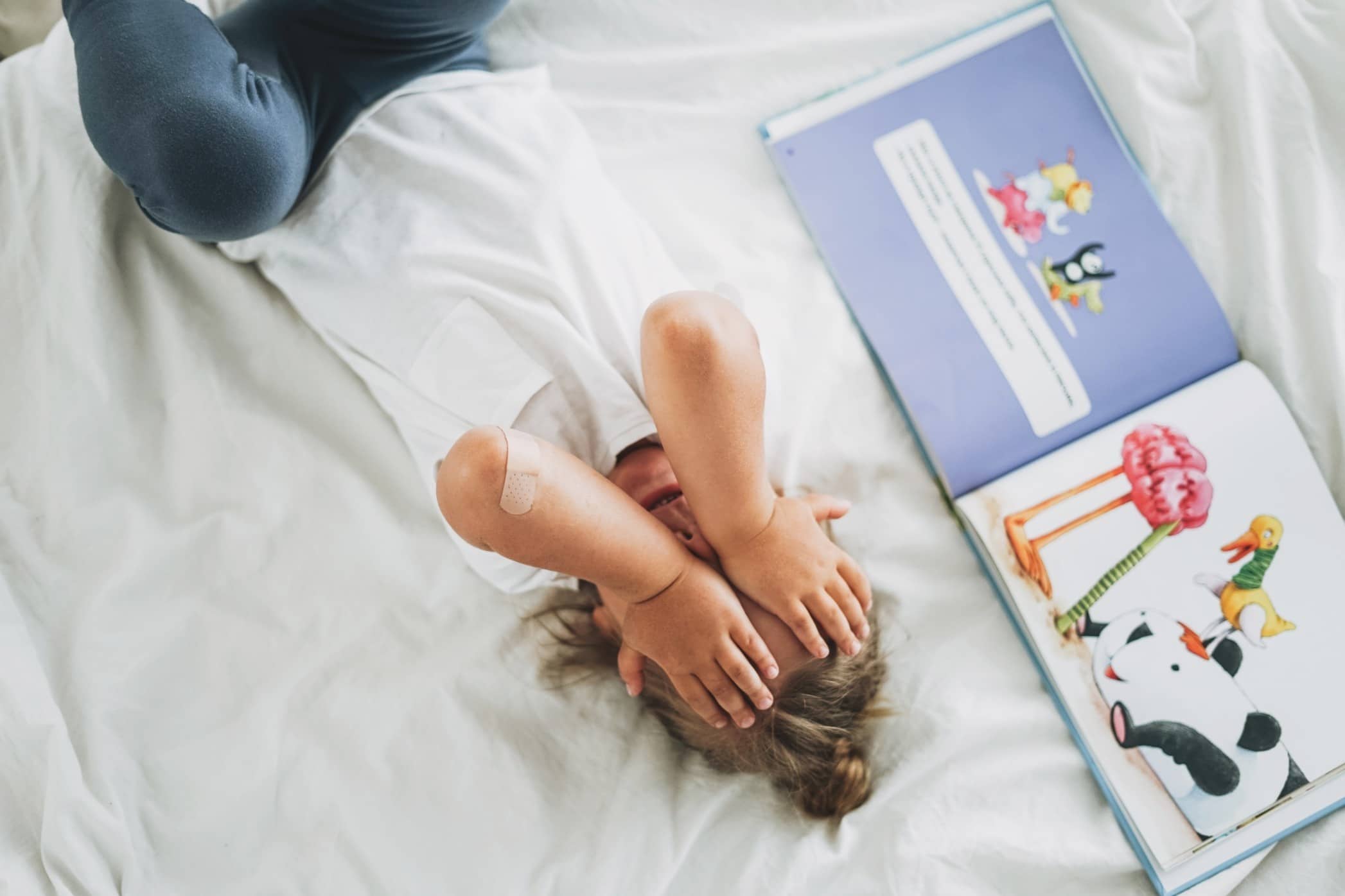 stress in children: mom sitting on bed with hands over head