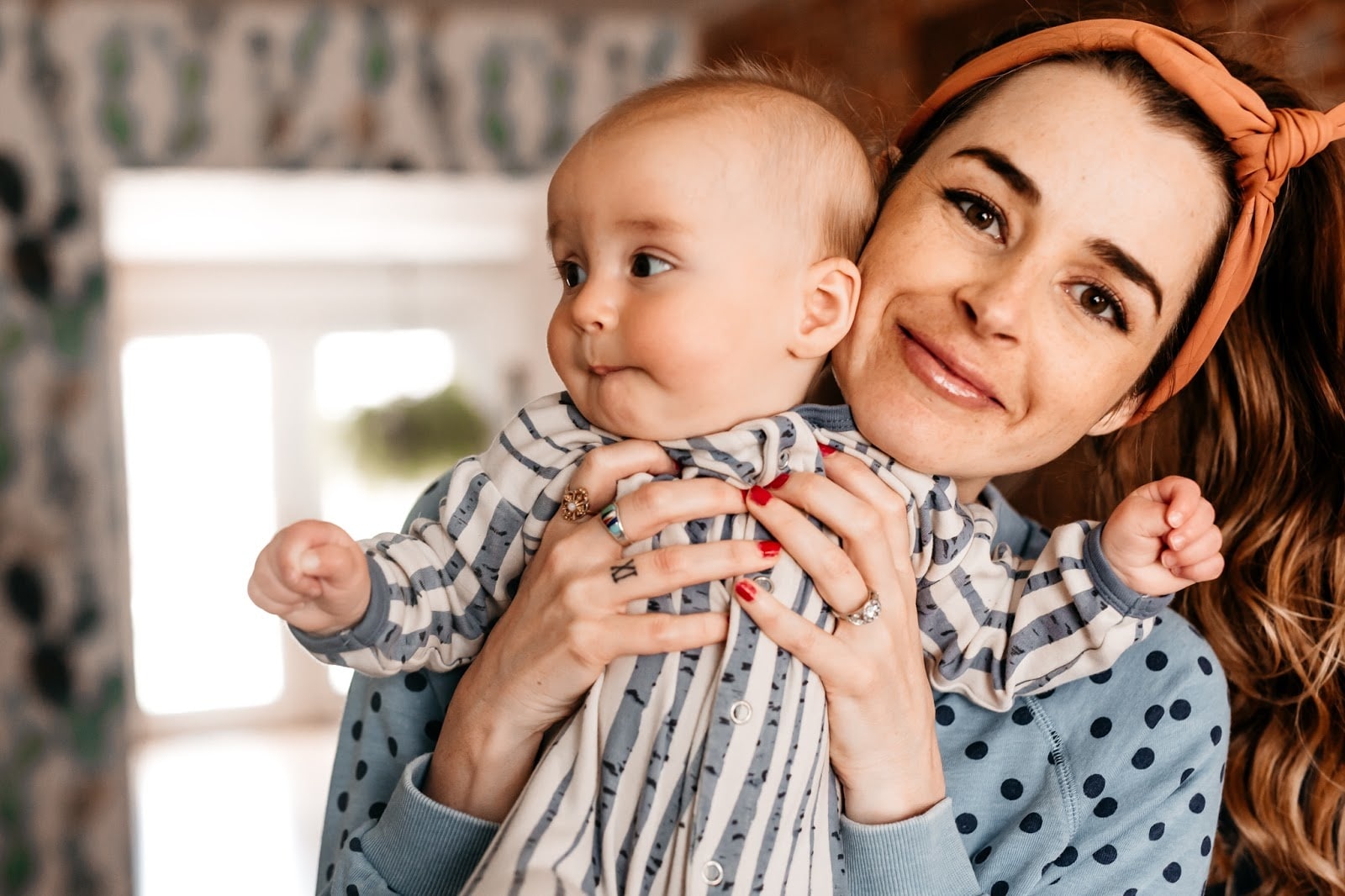 woman holding up newborn baby