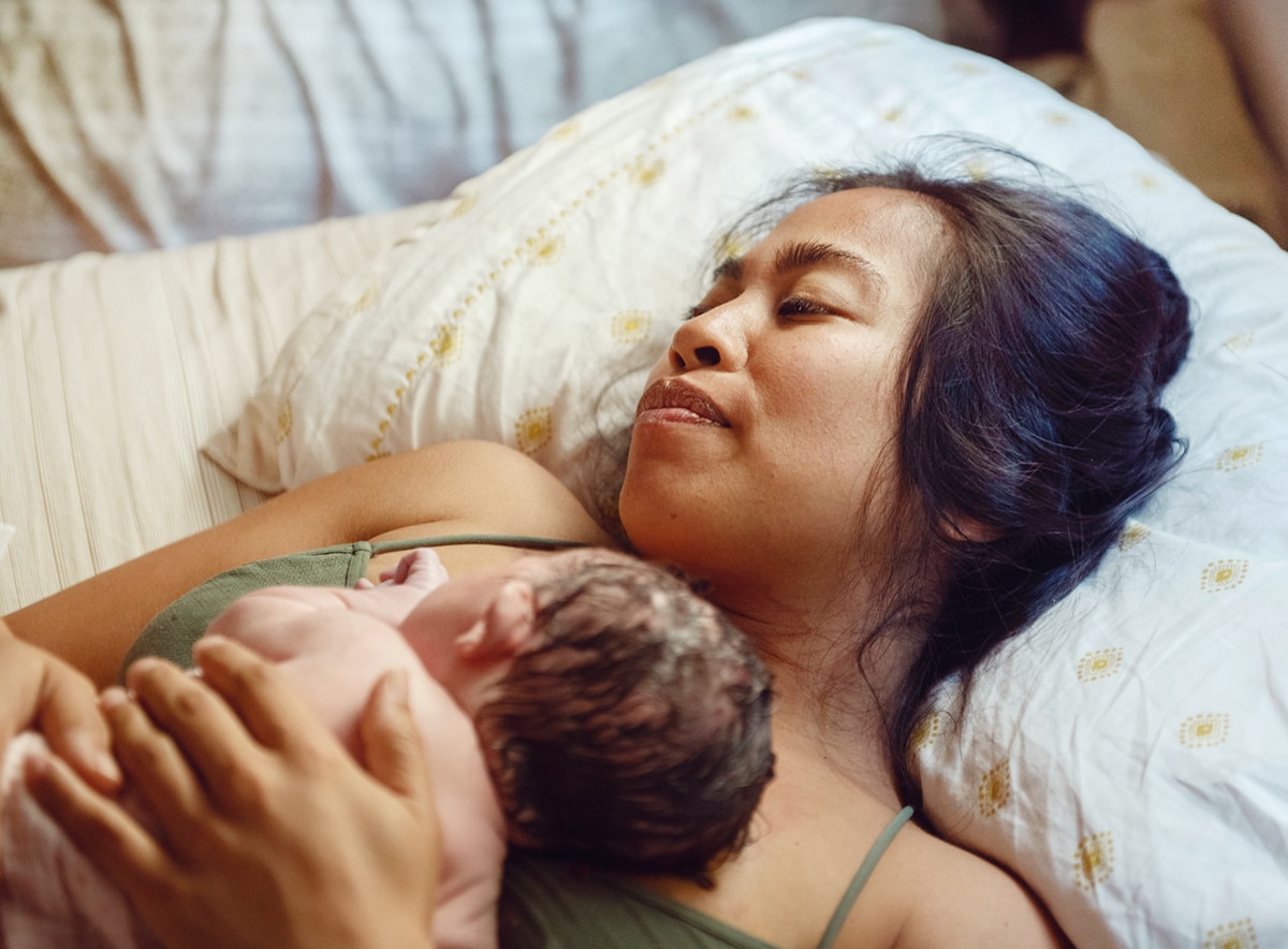 mom holding newborn baby against her chest