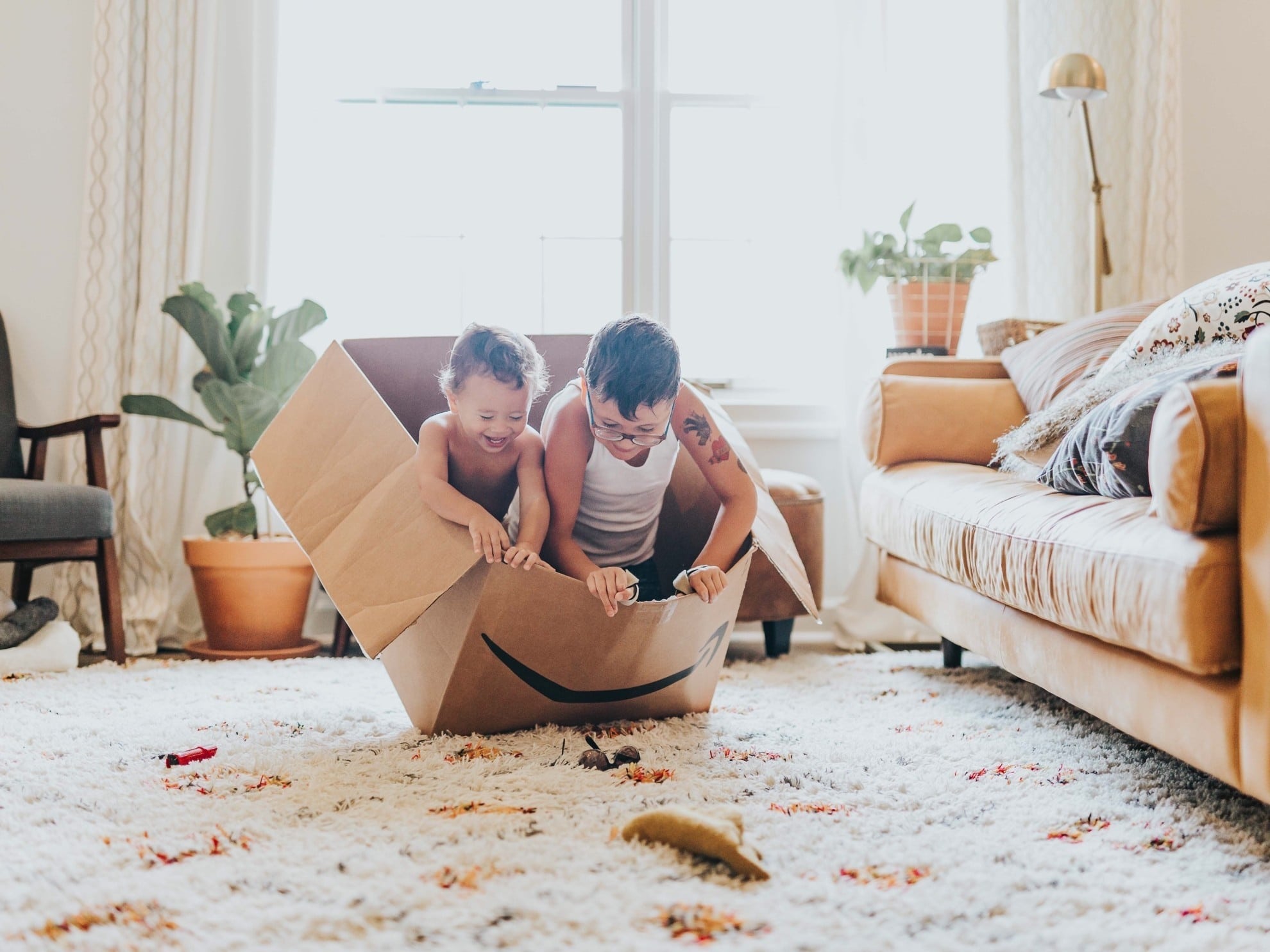 two boys playing in an Amazon box