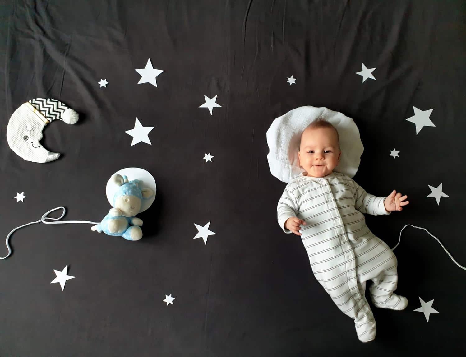 baby laying on a galaxy blanket- baby names that mean moon
