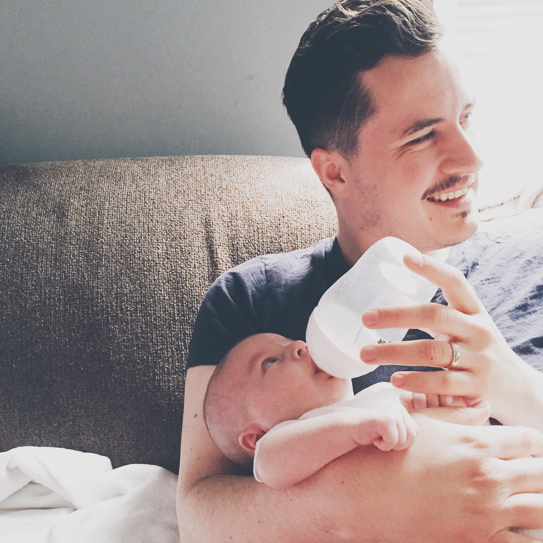 dad giving a baby a bottle - 4-week-old baby feeding schedule