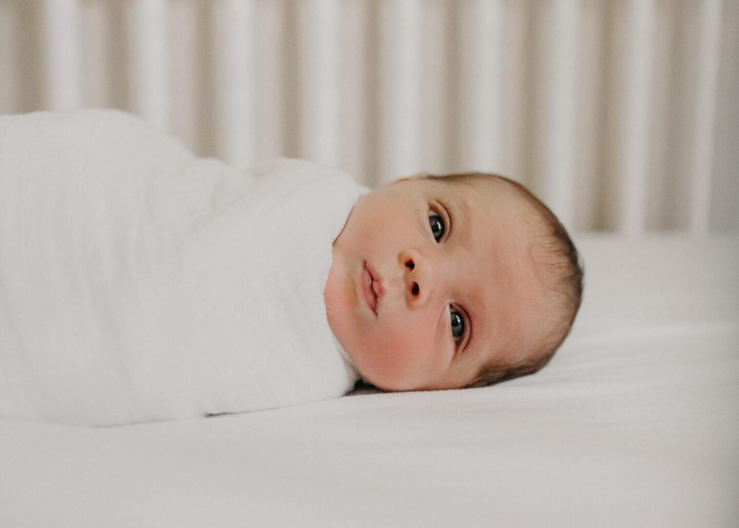 baby swaddled in a crib