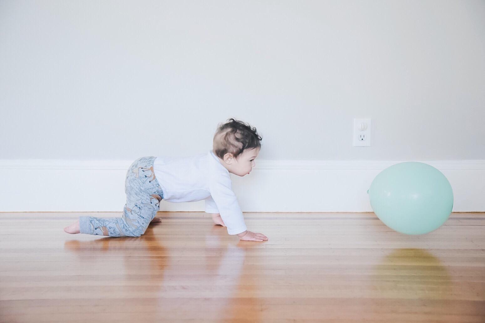 baby crawling towards balloon - 10-month milestones