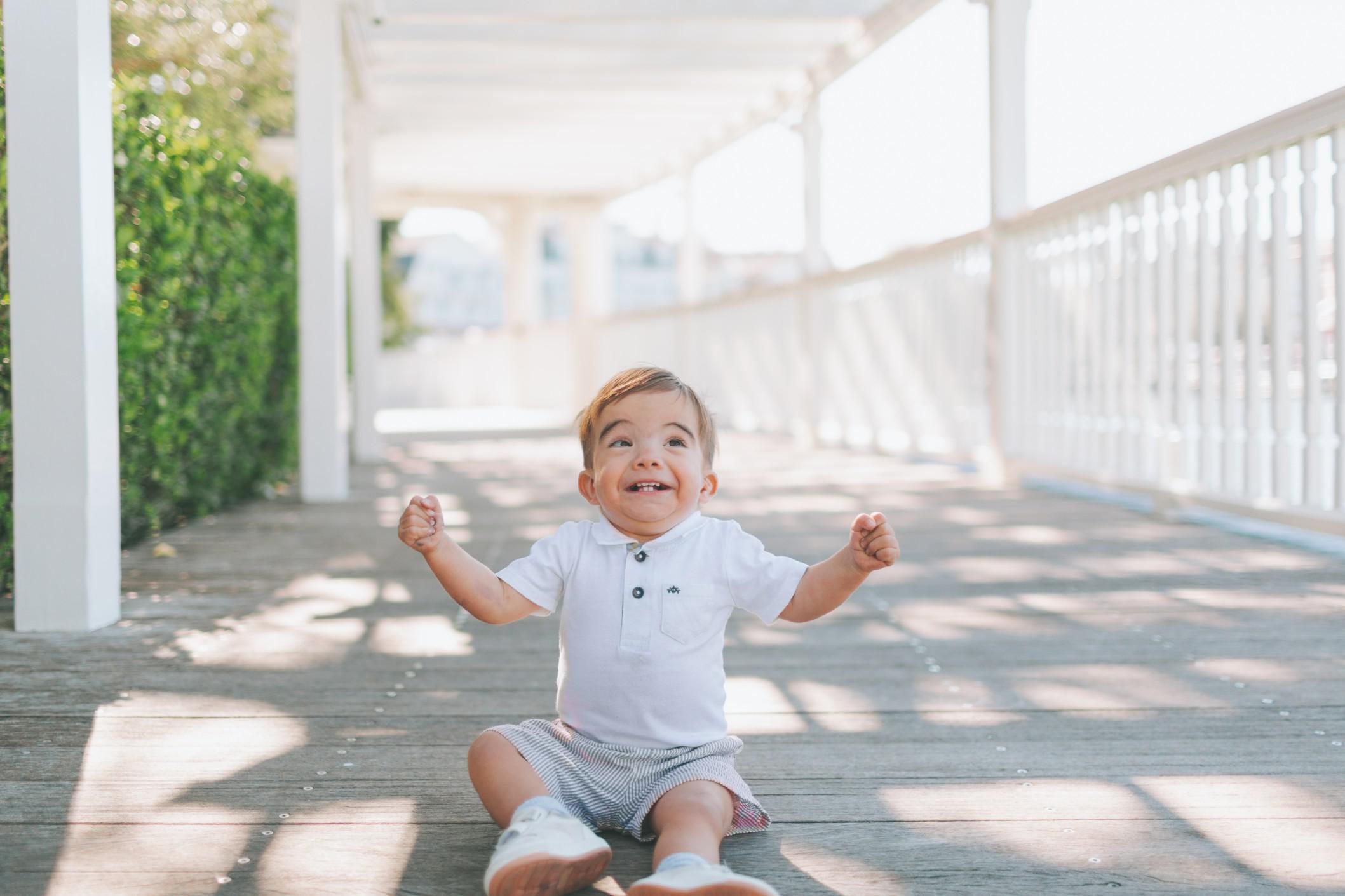 happy child sitting on the sidewalk