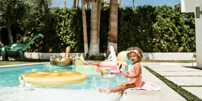 child sitting on the edge of a pool