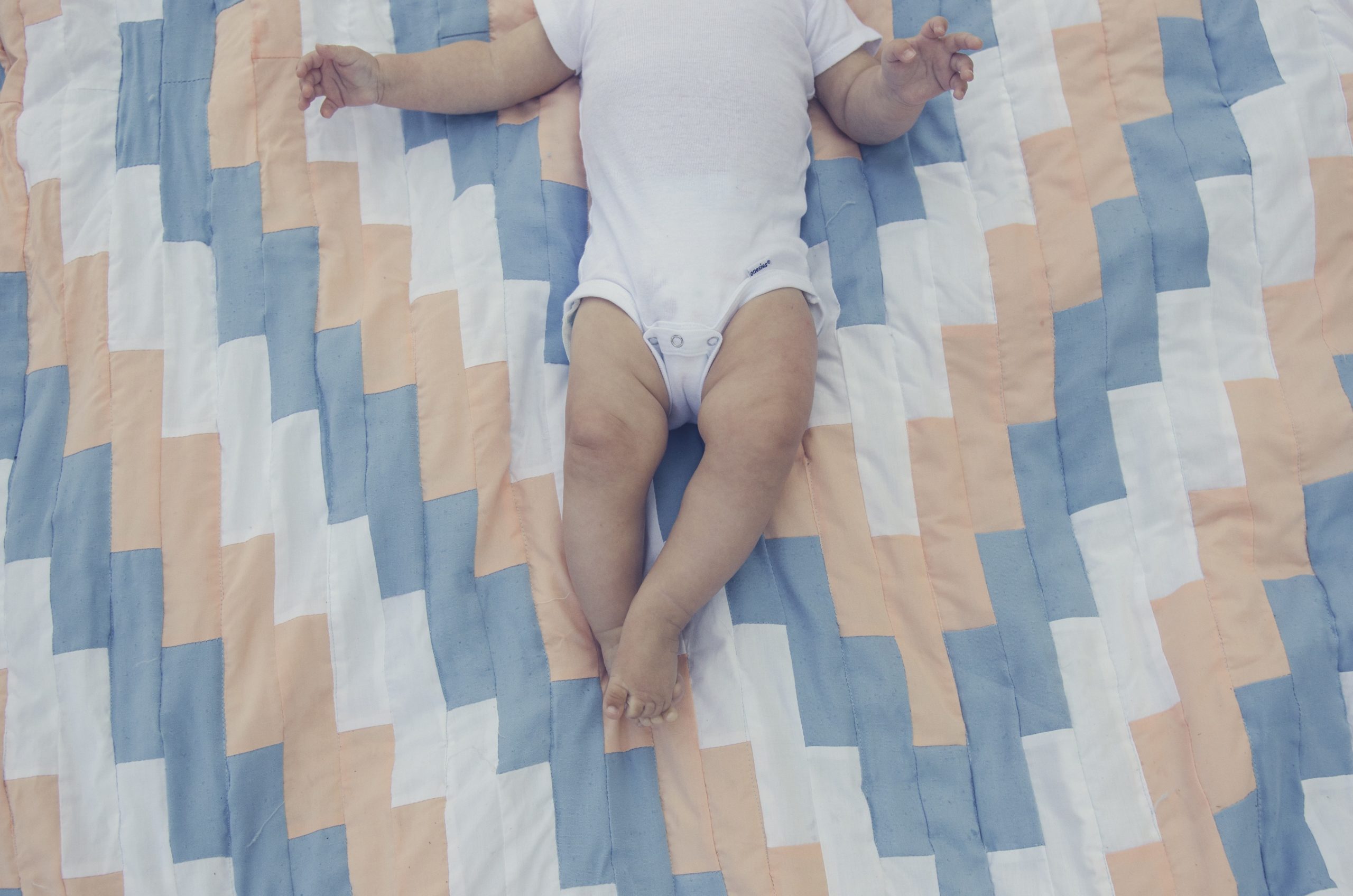 baby lying on quilt - activities for 4-month-old