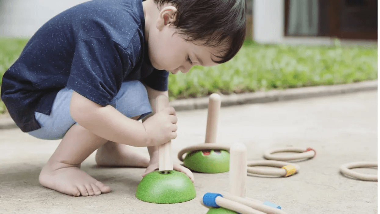 child playing with wooden toys